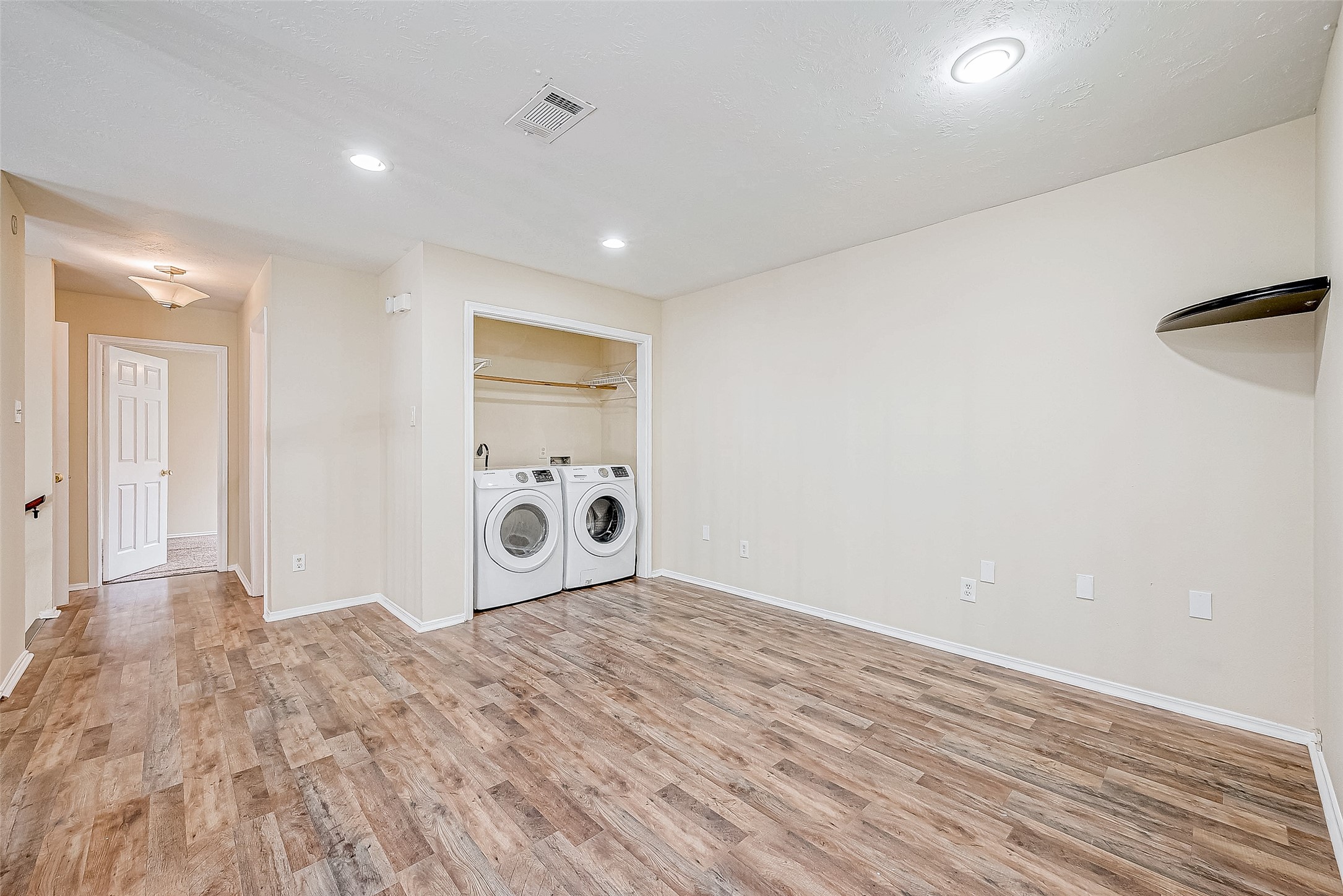 Located near the upstairs landing, the laundry area provides a well-lit, spacious layout with recessed lighting and plenty of room to accommodate your needs. Its thoughtful placement ensures ease of access and functionality.