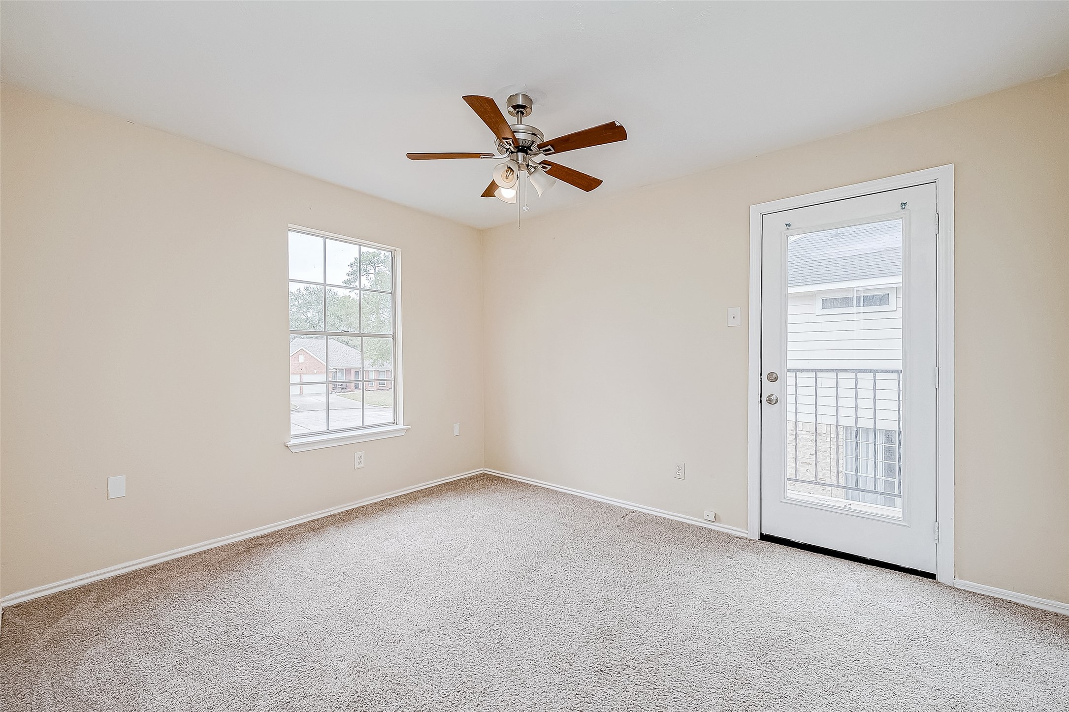 This secondary bedroom offers a bright and airy retreat, with a large window that welcomes abundant natural light. The glass-paneled door leads to a private balcony, adding a unique touch to the space.