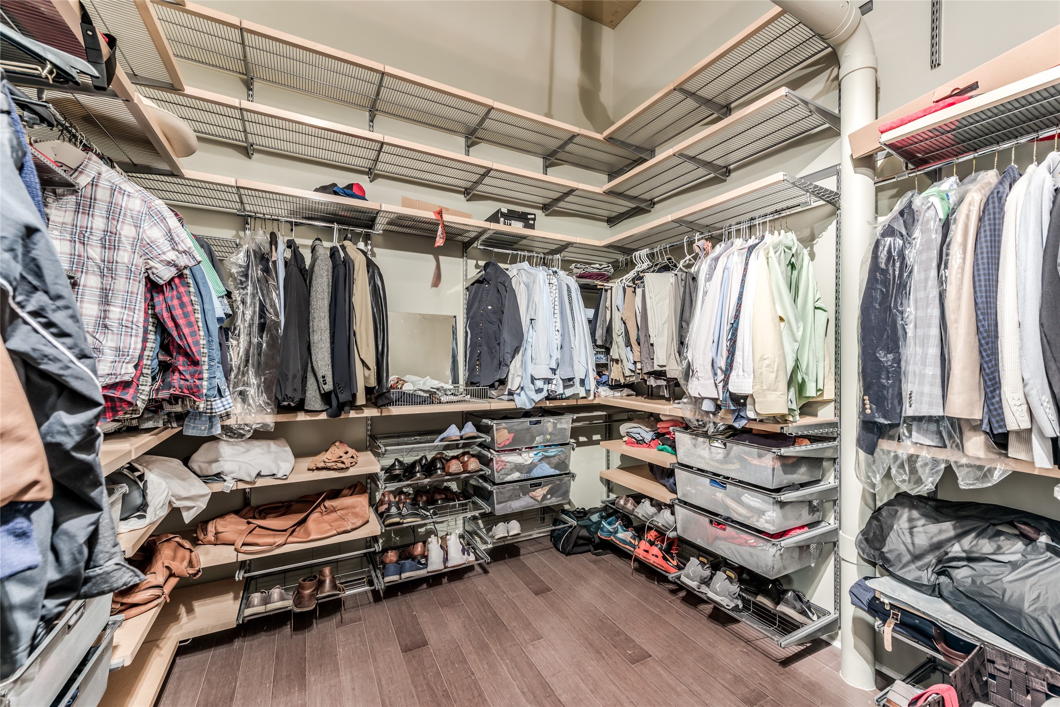 This spacious walk-in closet features ample shelving and hanging space, perfect for organizing clothing and accessories.