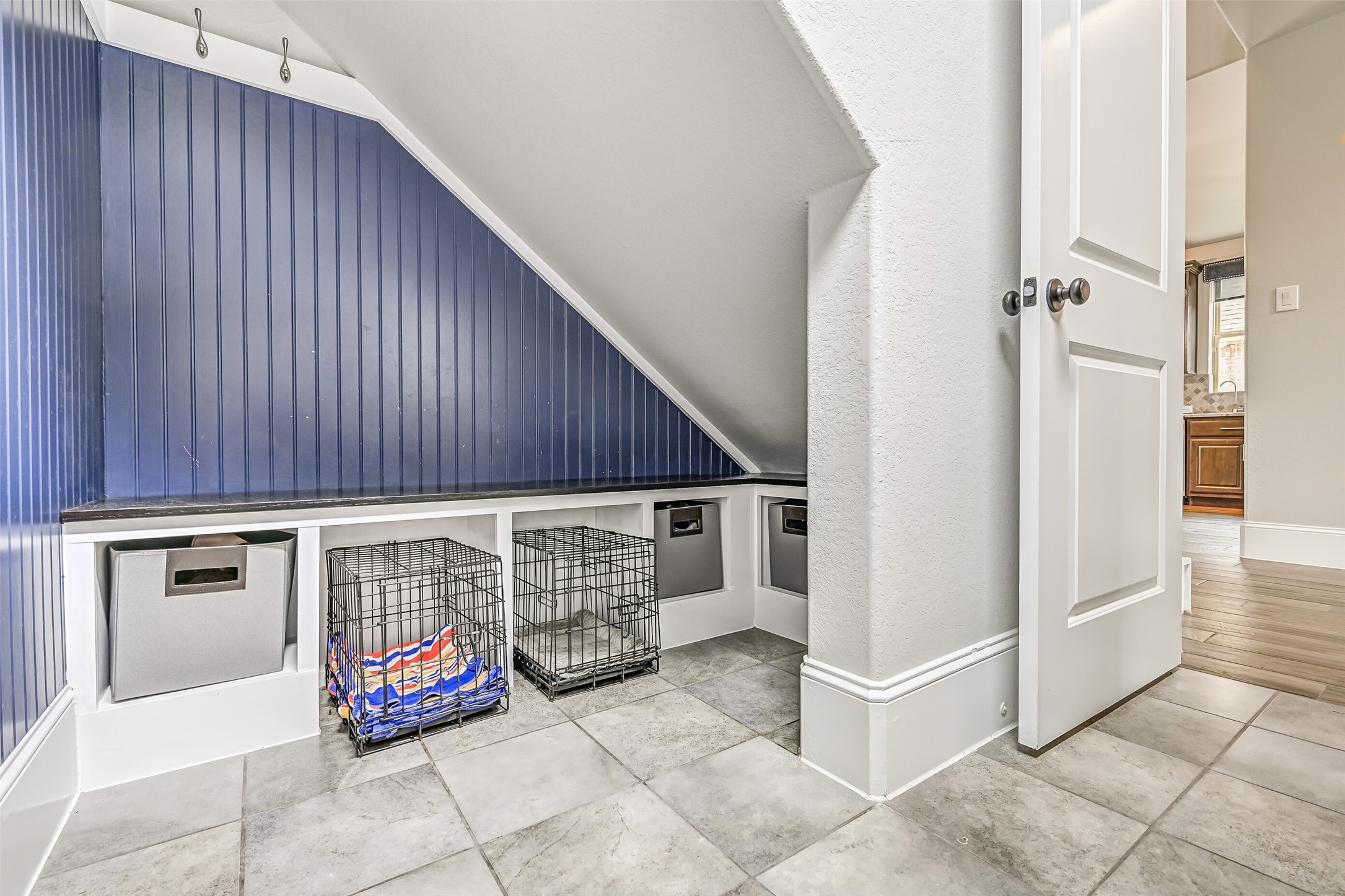 A clever use of space beneath the staircase creates a custom storage and pet nook with built-in cubbies, hooks and bench-height surface. The nearby garage door is equipped with a convenient keyless electronic lock.