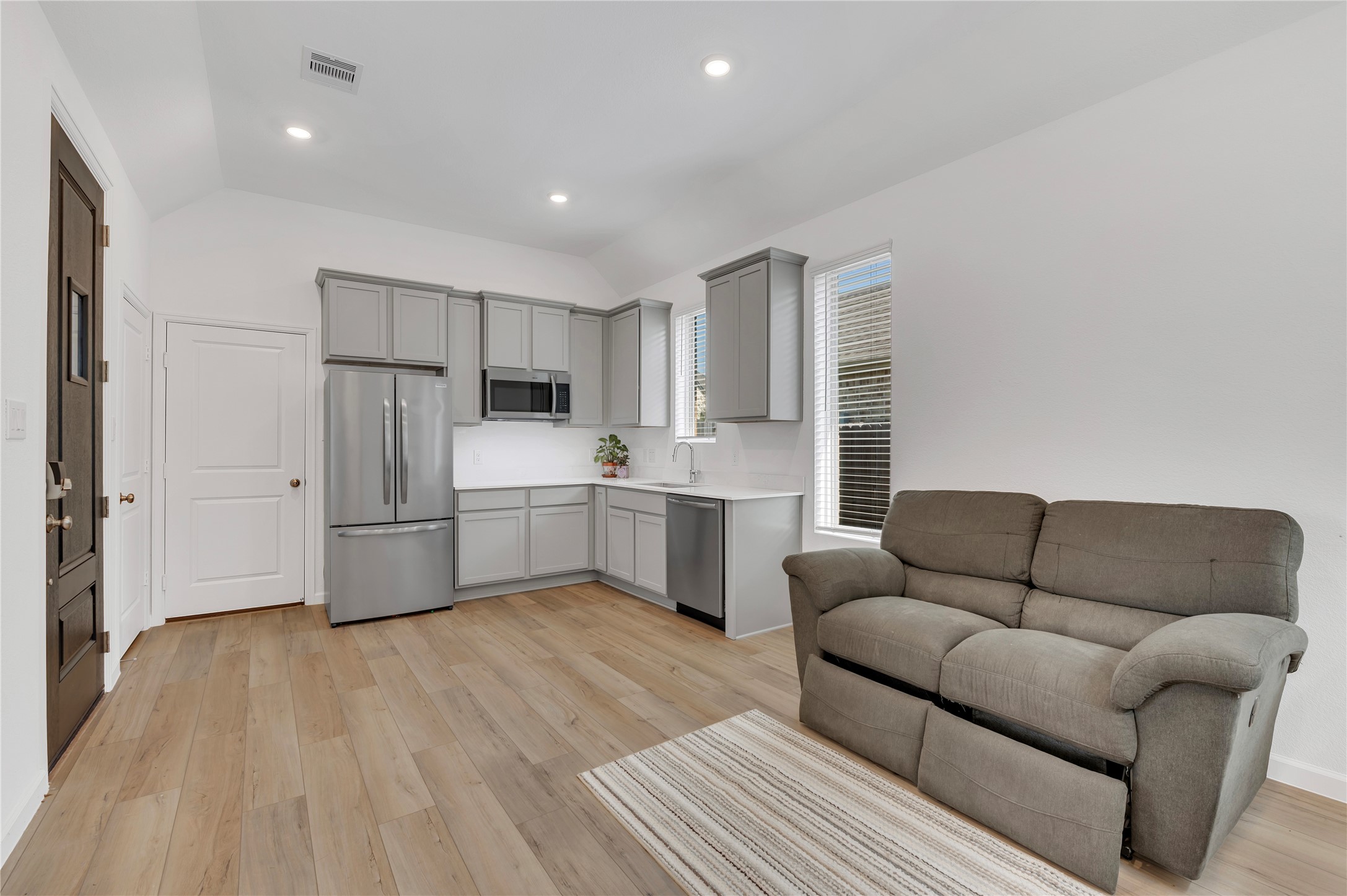 Lock off suite with kitchen including fridge, dish washer, microwave, farmhouse sink, quartz countertops, plenty of cabinet space, and washer/dryer hook ups in the closet!