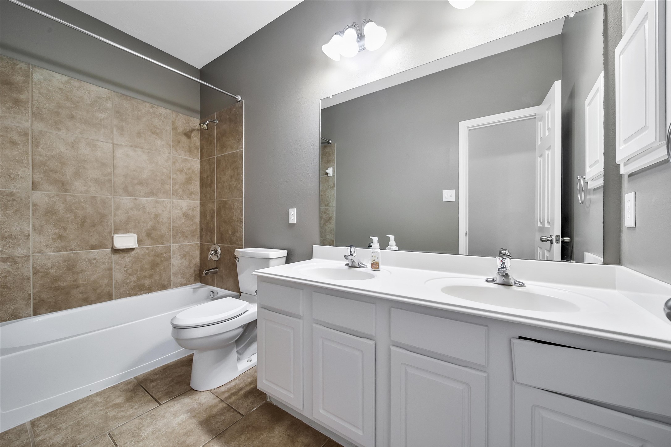 Secondary bathroom features double sinks and a spacious vanity. Conveniently located by the secondary bathrooms in this split floorplan.