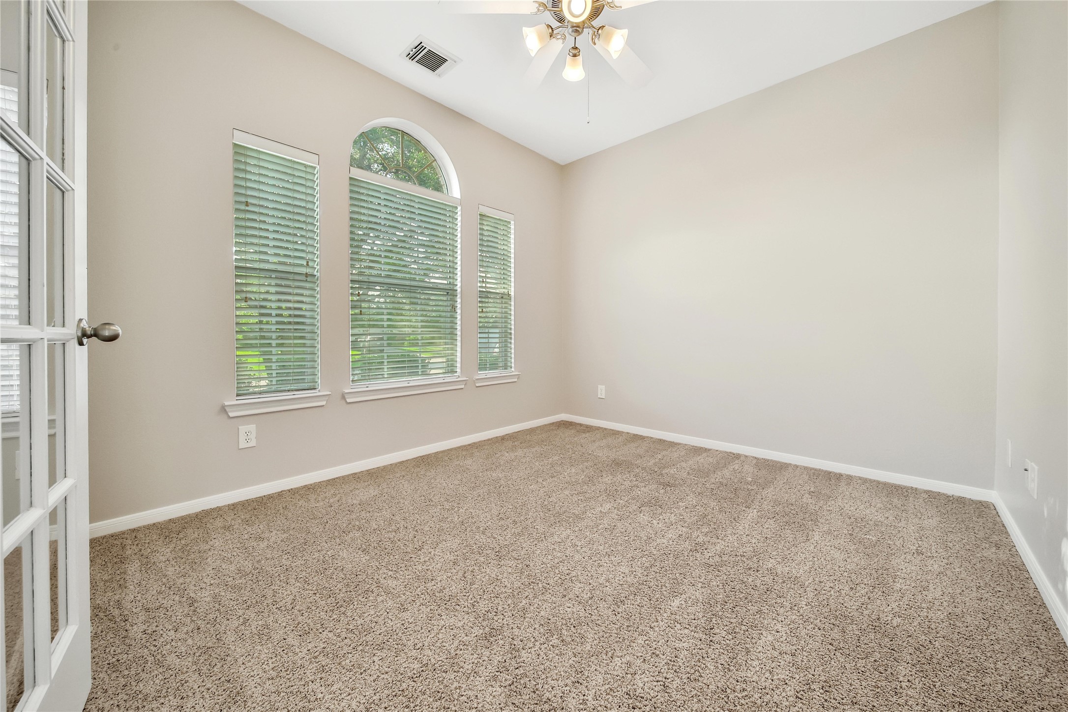 The study/flex room with french doors offers flexibility in how the space is used. Featuring a bright window to the front yard with views of the mature oak tree.