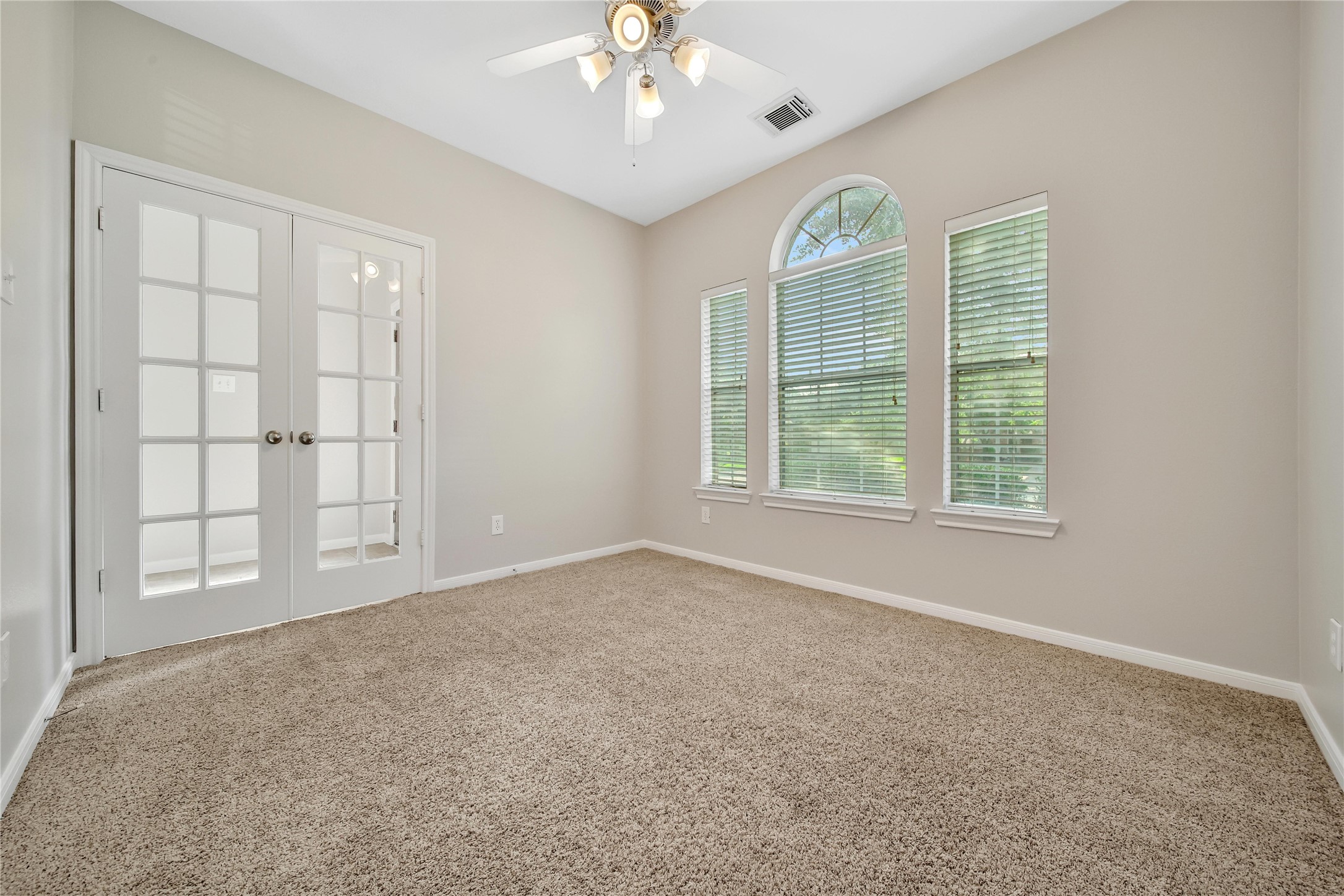 The study/flex room with french doors offers flexibility in how the space is used. Featuring a bright window to the front yard with views of the mature oak tree.