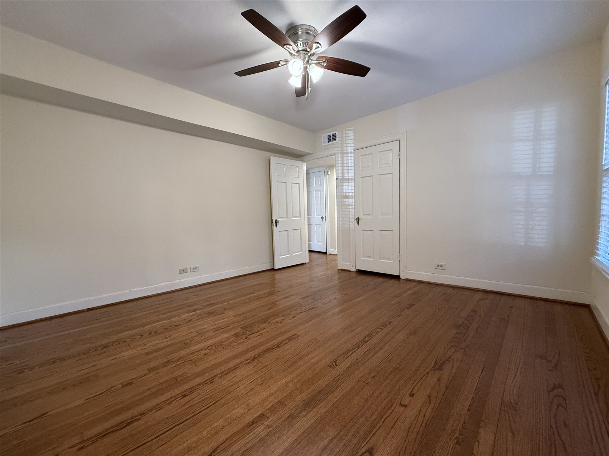 Alternate view of the primary bedroom. Behind the closed door on the opposite side of the room is another closet.