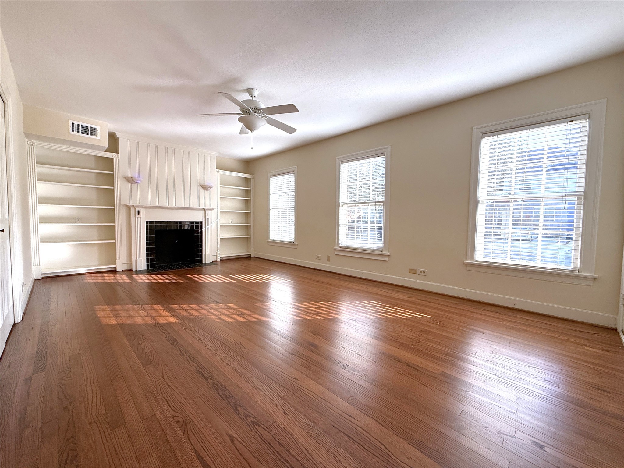 Welcome home! The living room offers a ceiling fan w/light fixture, mock fireplace, built-in shelving & sconce lighting. Natural light flows in from tri windows.