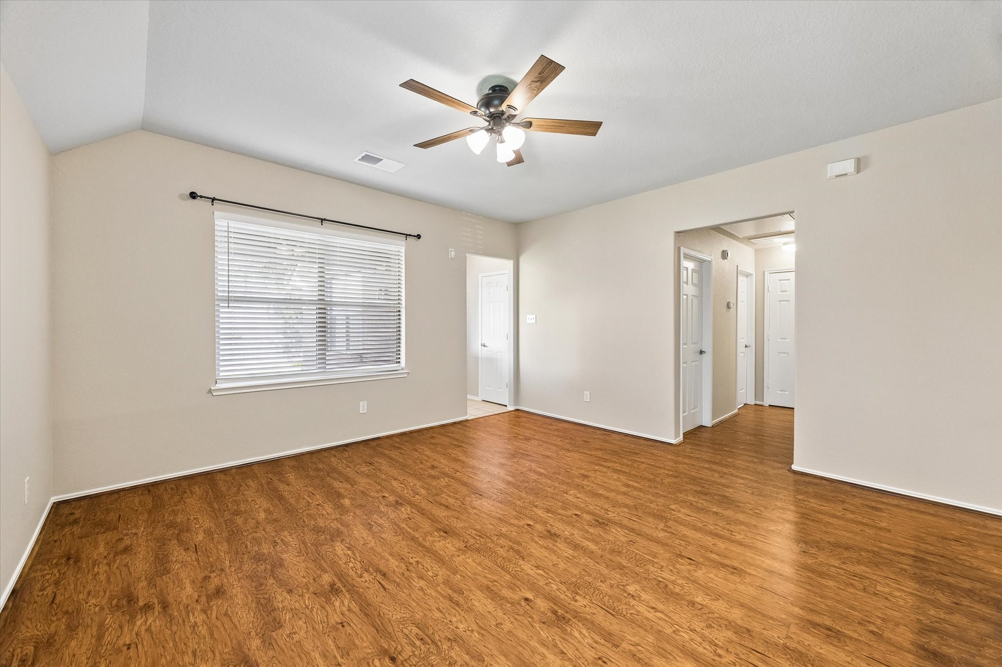 Open floor plan create a comfortable gathering space with updated ceiling fan and neutral interior colors.