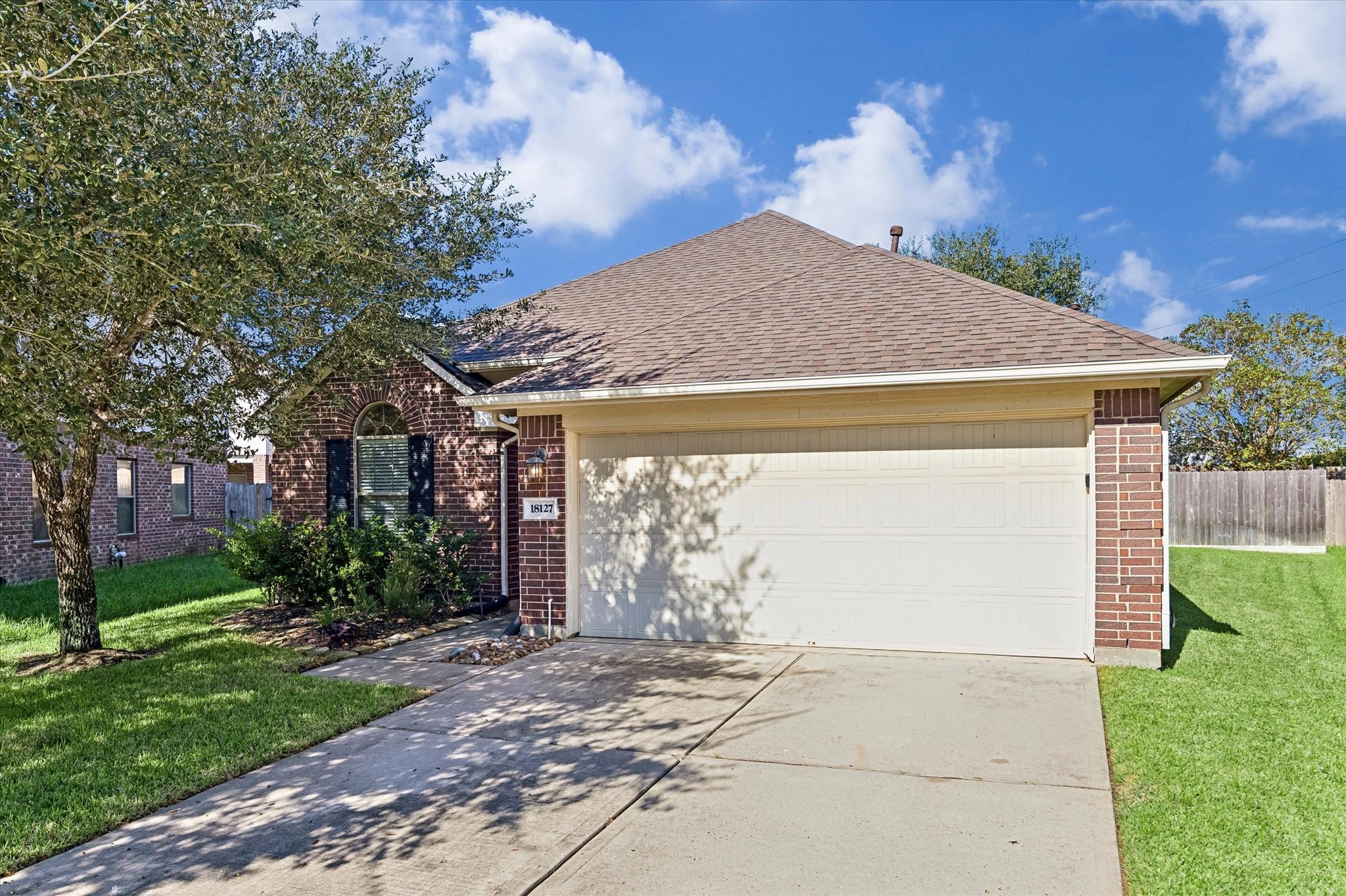 Attractive brick exterior featuring a two-car attached garage, mature shade trees, and established landscaping. Roof replaced approximately 2 years ago!