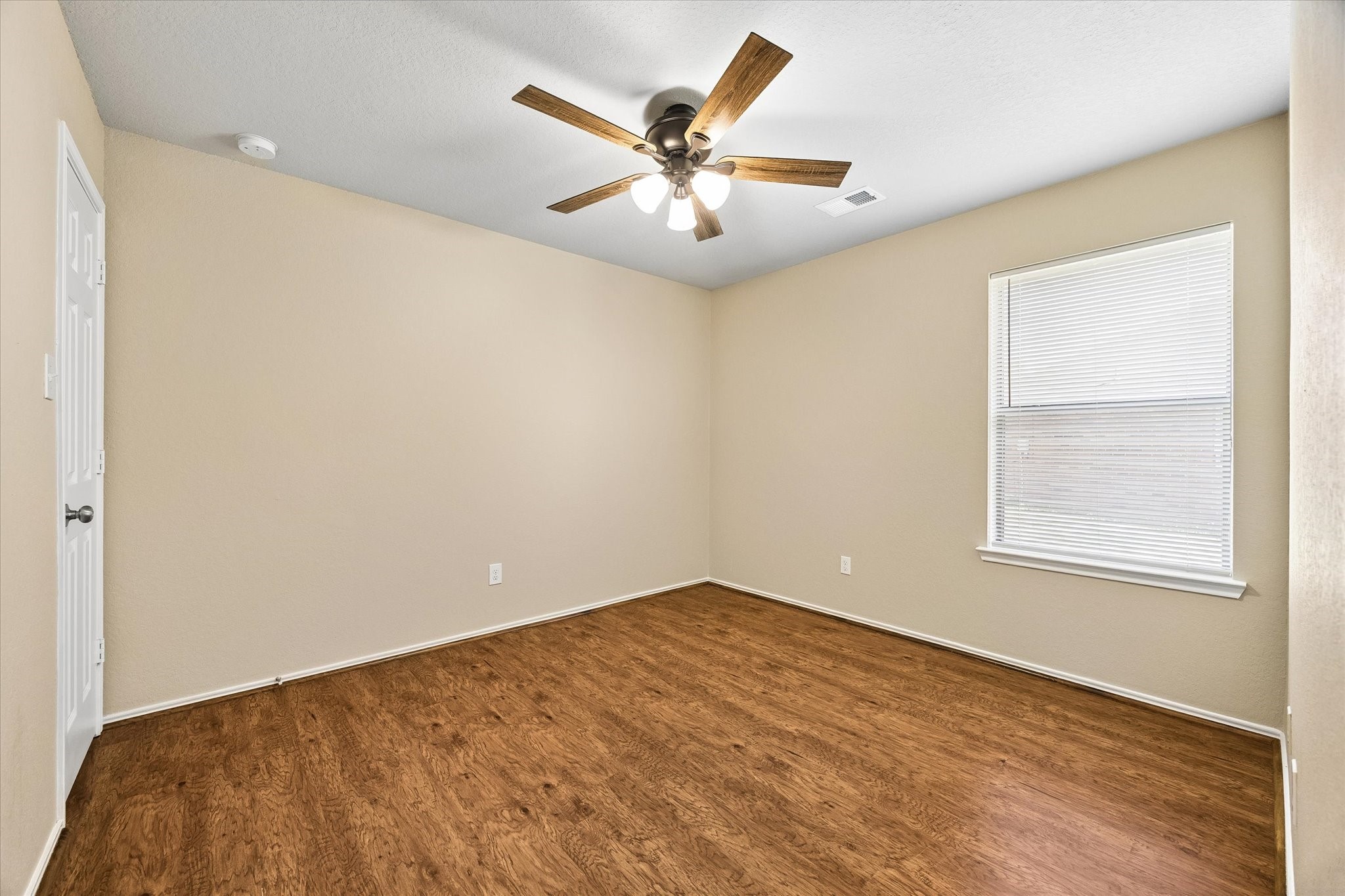 Secondary bedroom featuring wood-look flooring, fresh interior paint, and a NEW ceiling fan.