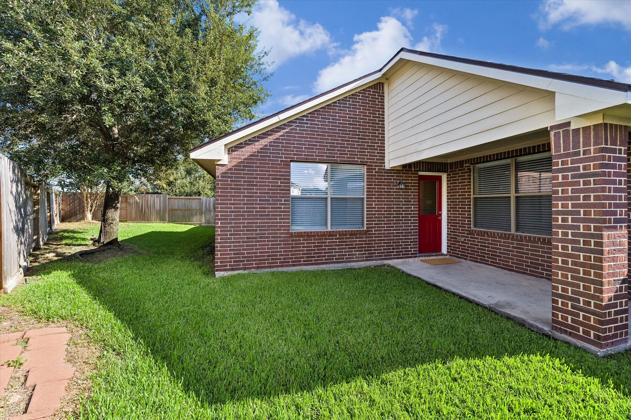 Covered back patio with convenient access to the backyard. A comfortable spot for grilling, outdoor seating, or relaxing.