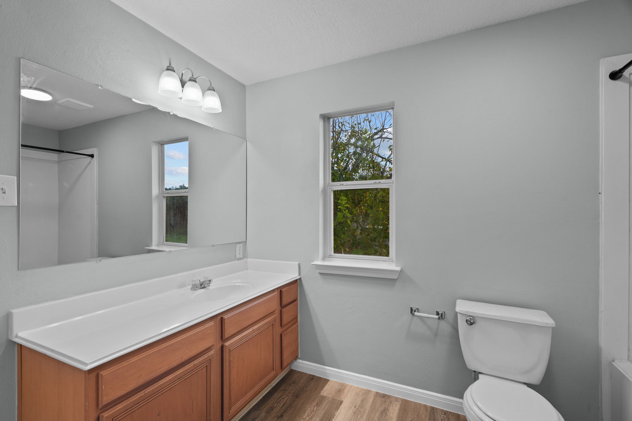 Bright and modern bathroom with a spacious vanity, sleek mirror, and natural light.