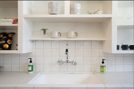 Adorable vintage kitchen with open shelving and original tile.
