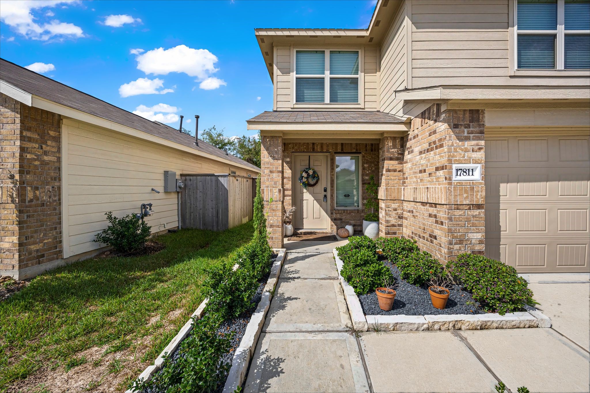 Covered front entry with brick surround and a landscaped walkway