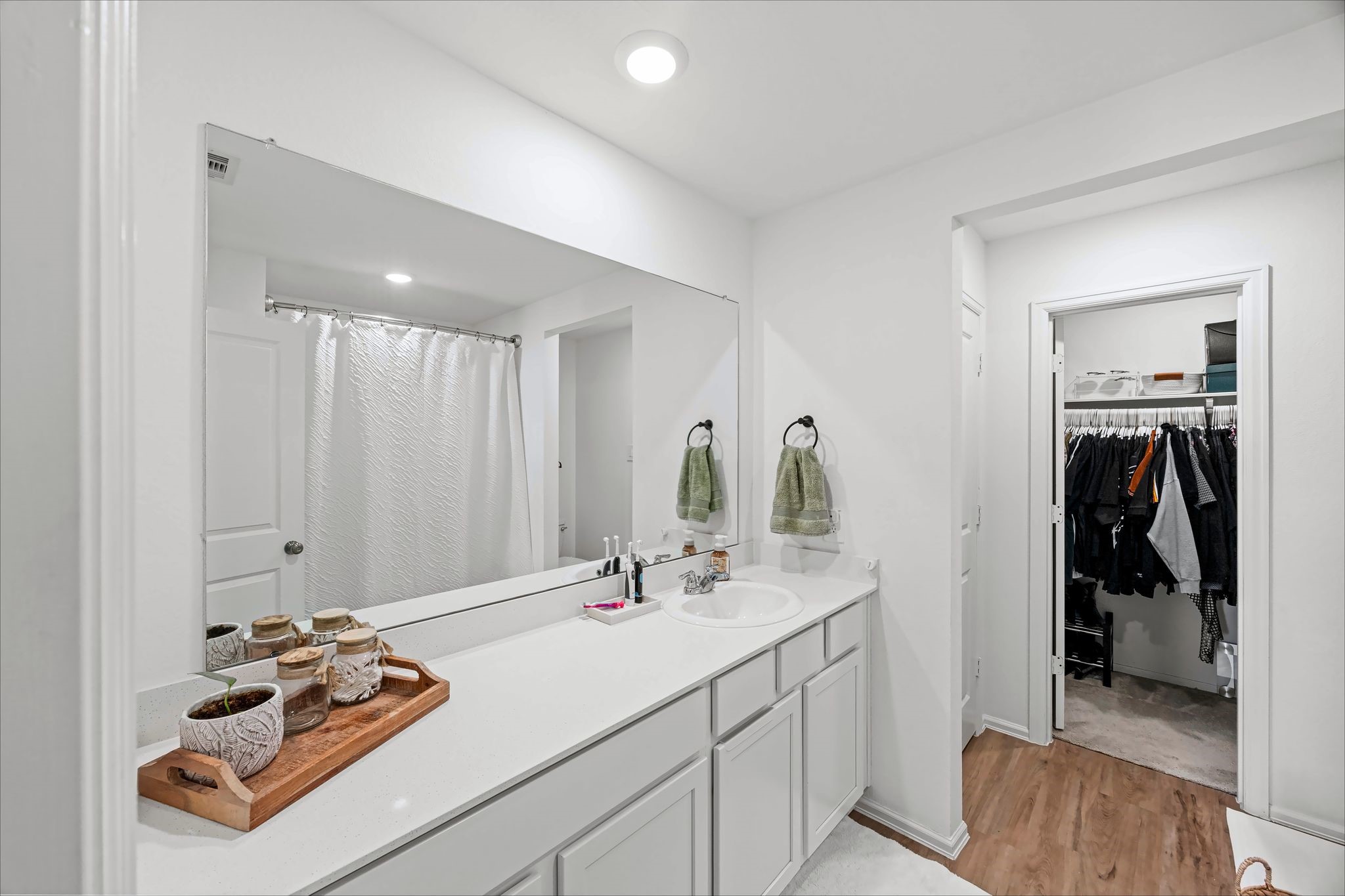Primary bath with a long vanity and access to the walk-in closet