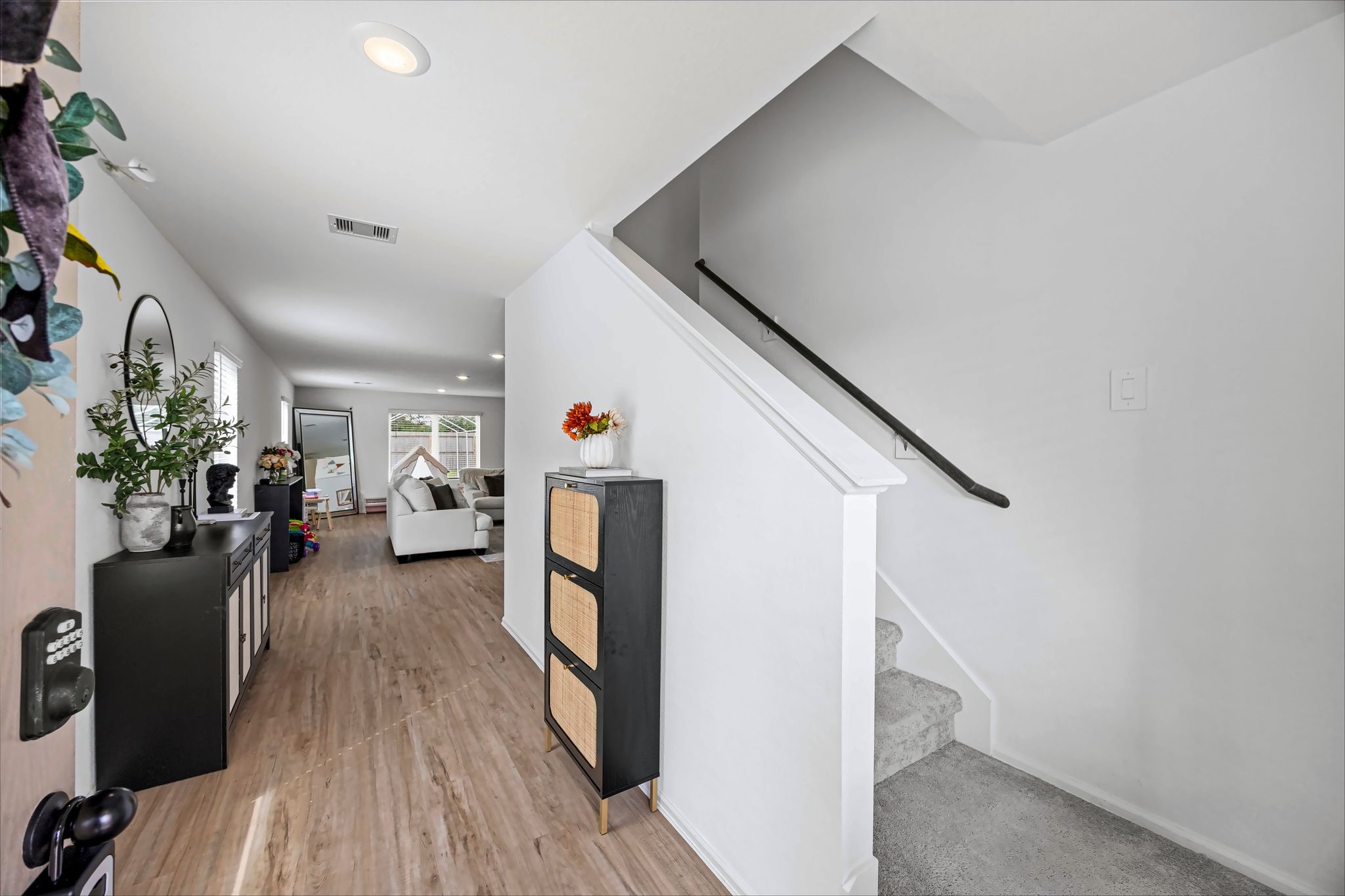 Entry foyer with wood-look flooring and a view into the main living area
