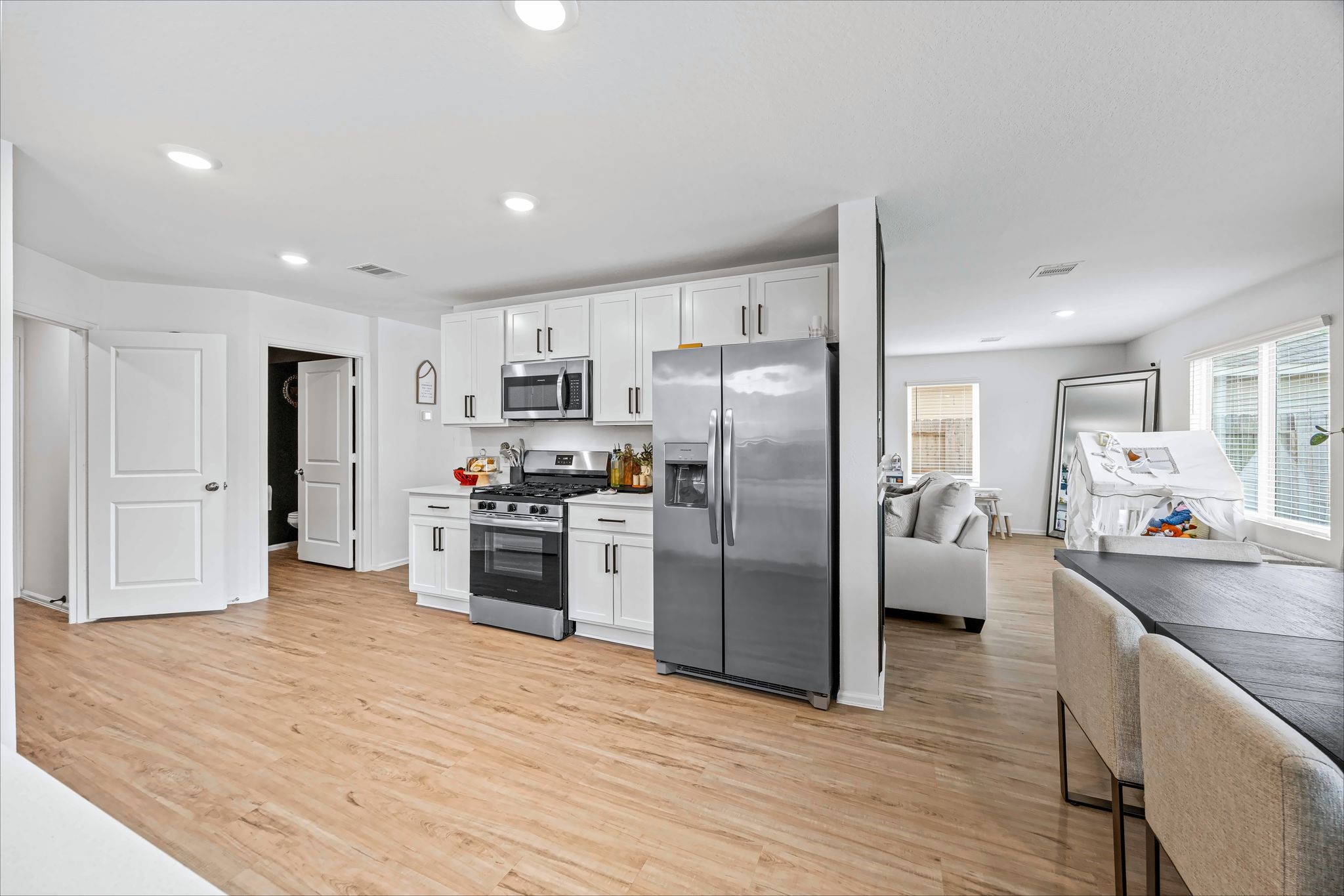 Kitchen with white cabinets, stainless appliances and an open layout