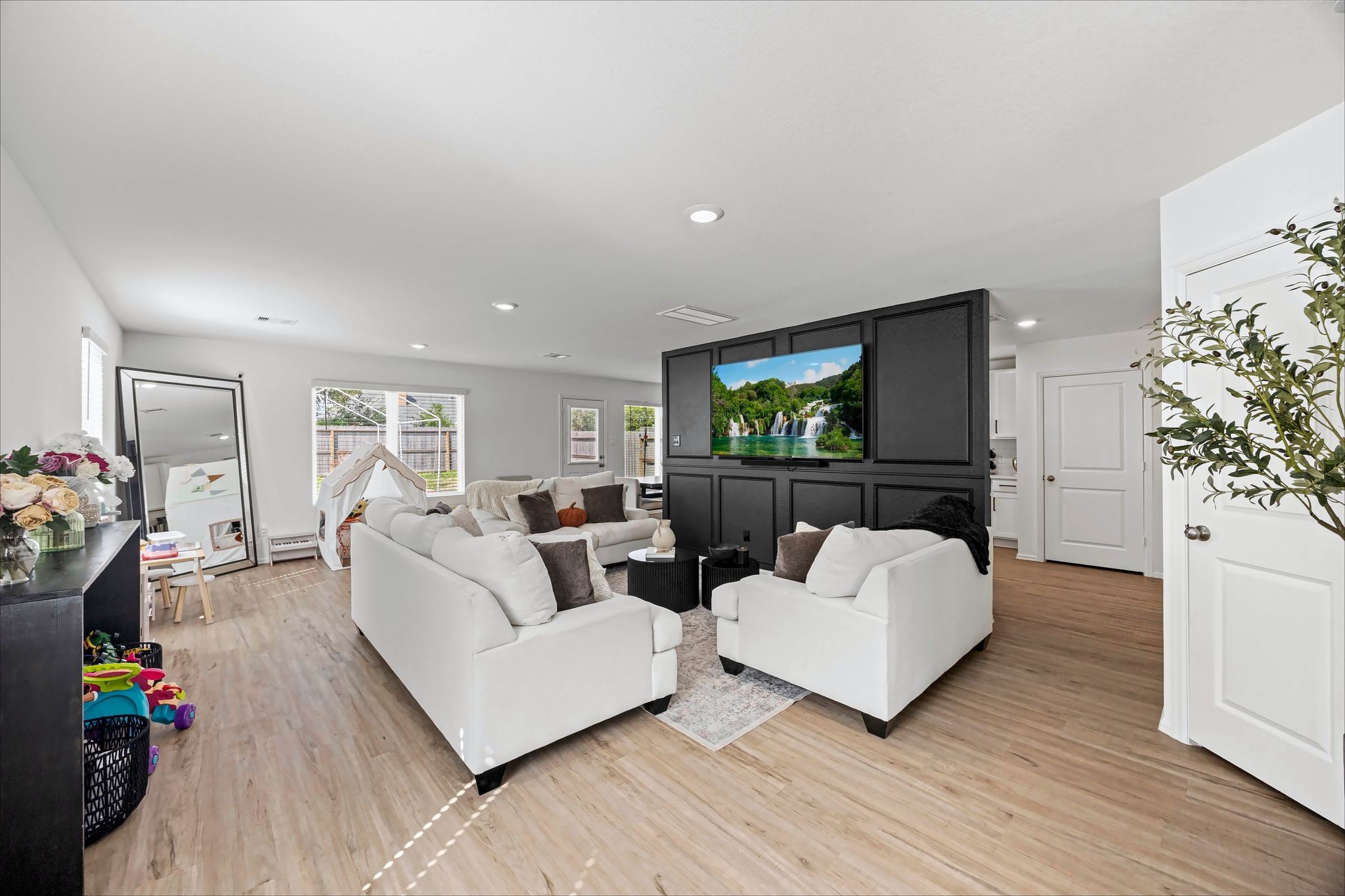 Open living room with recessed lighting and a feature wall for the TV