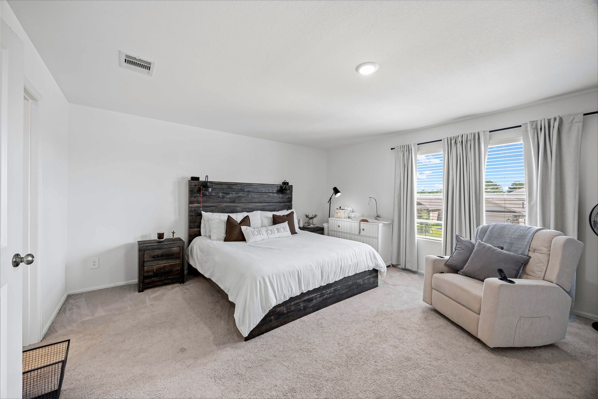 Primary bedroom with carpet and windows for natural light