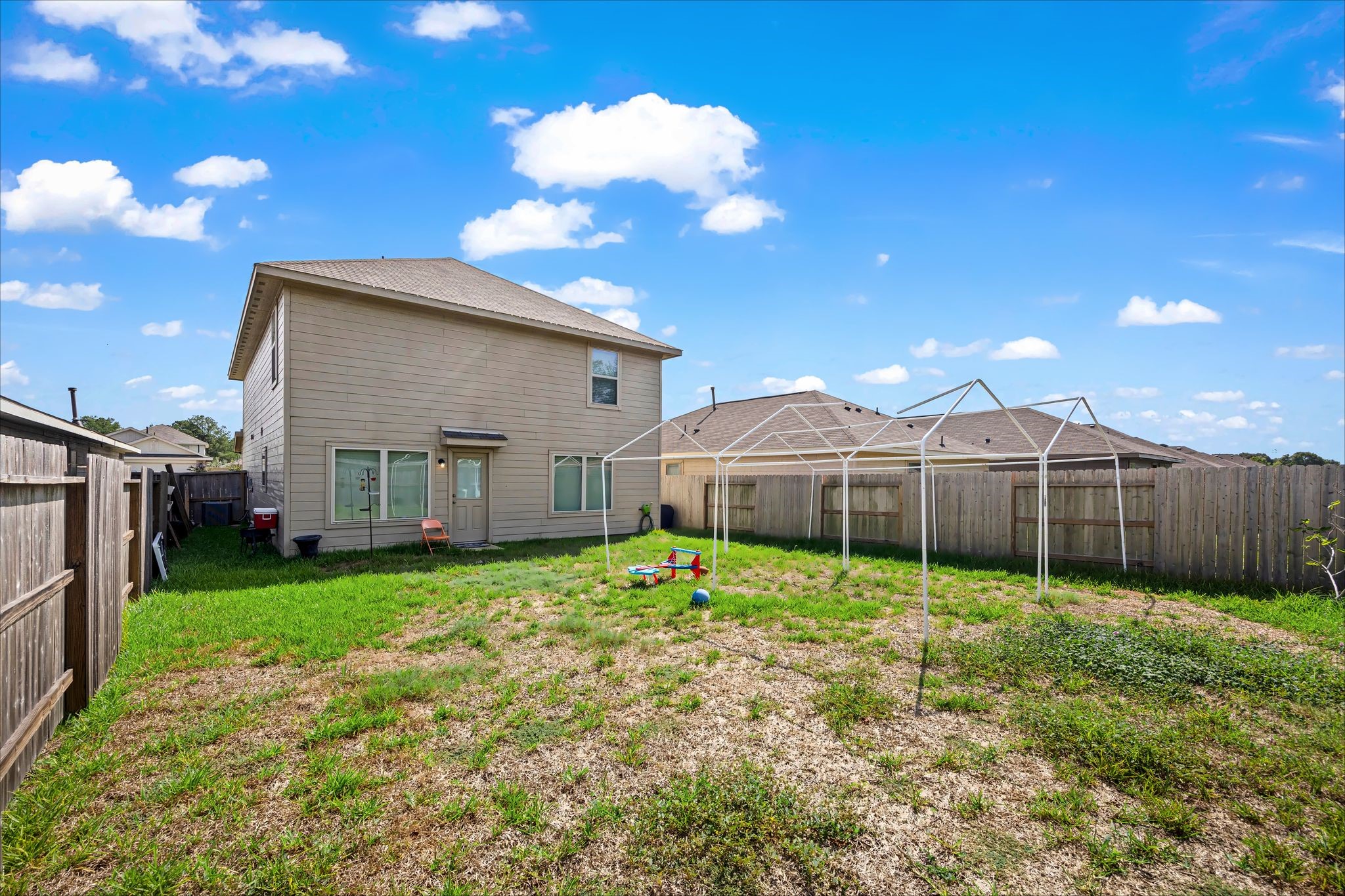 Large fenced backyard with lots of open grass