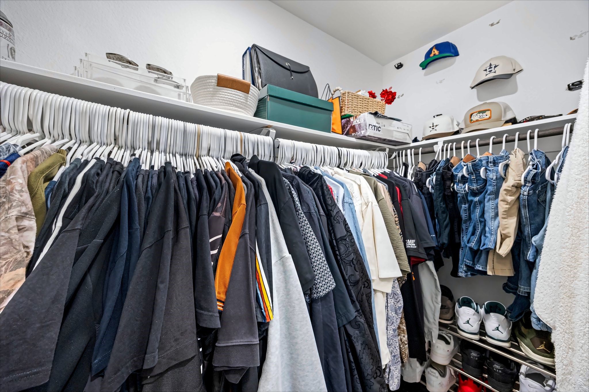 Walk-in closet with double hanging rods and upper shelving