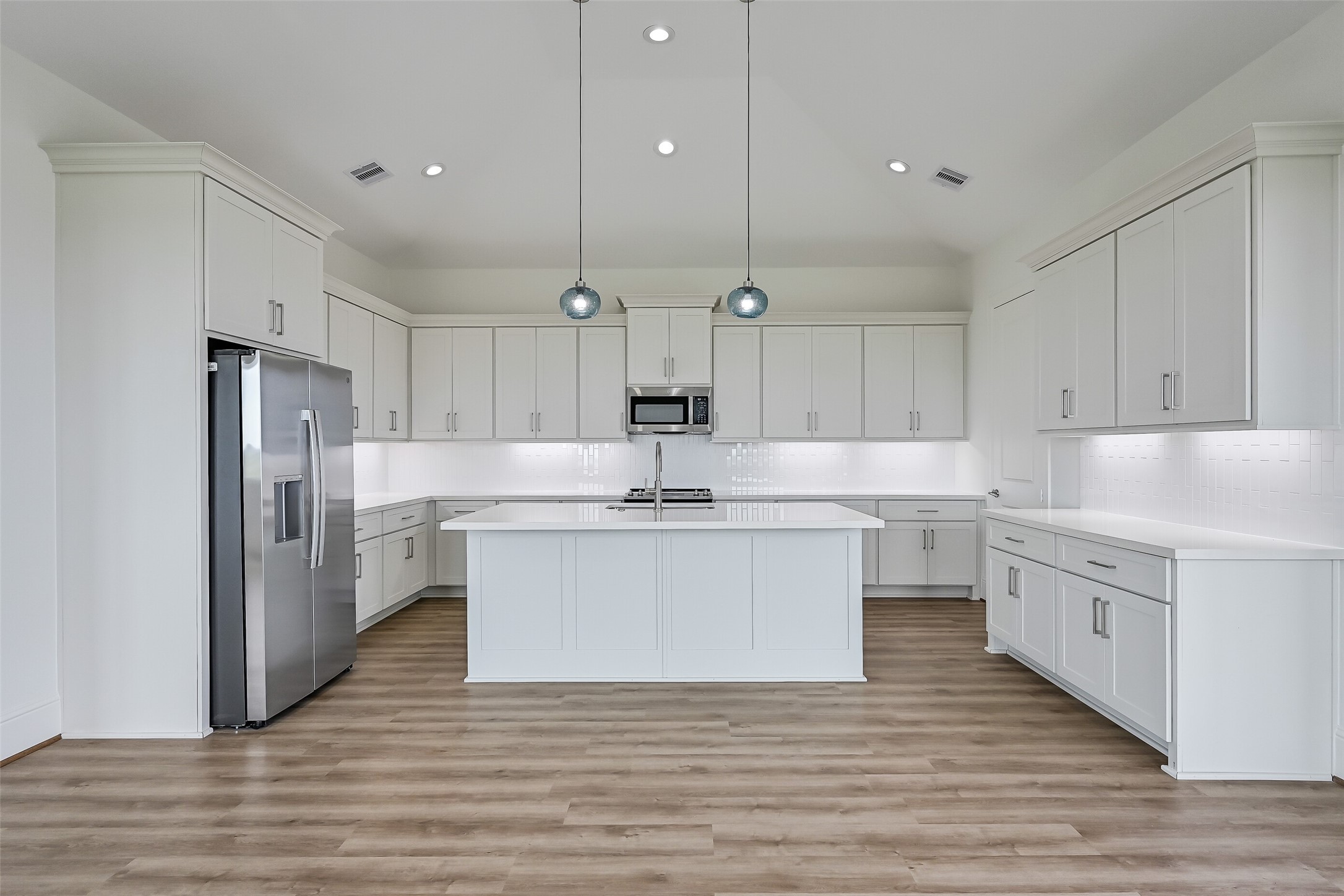 The spacious kitchen boasts ample cabinetry, stainless steel appliances, and a large center island.