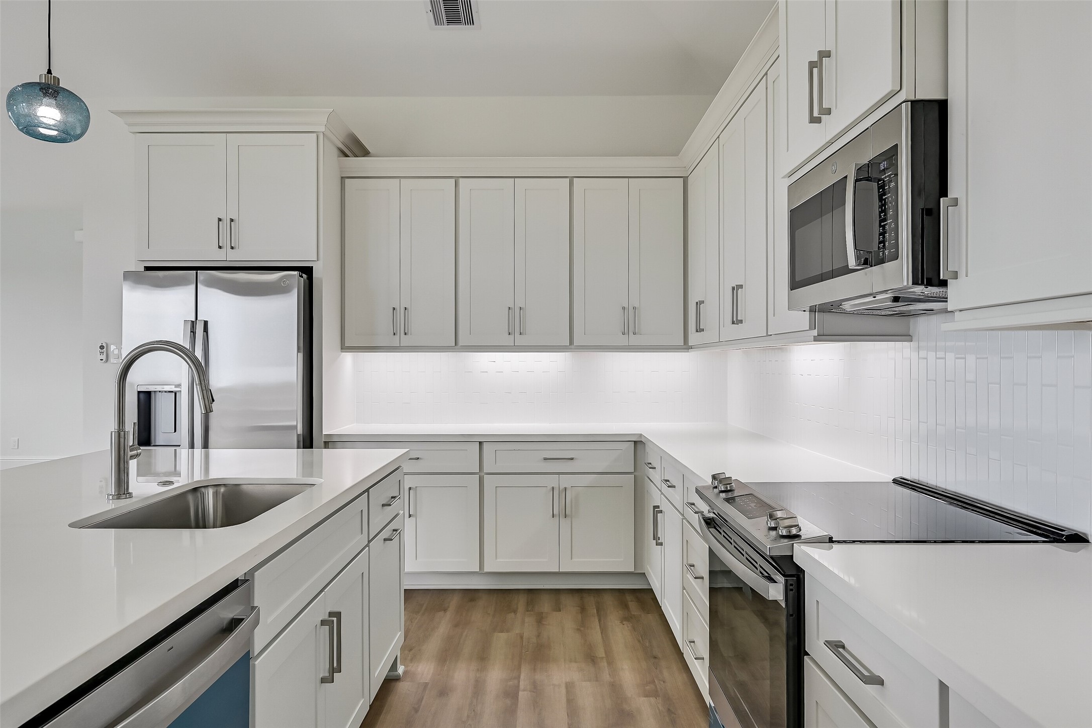 The kitchen is thoughtfully equipped with soft-close cabinets and drawers, along with under-cabinet lighting that adds both functionality and a touch of elegance to the space.
