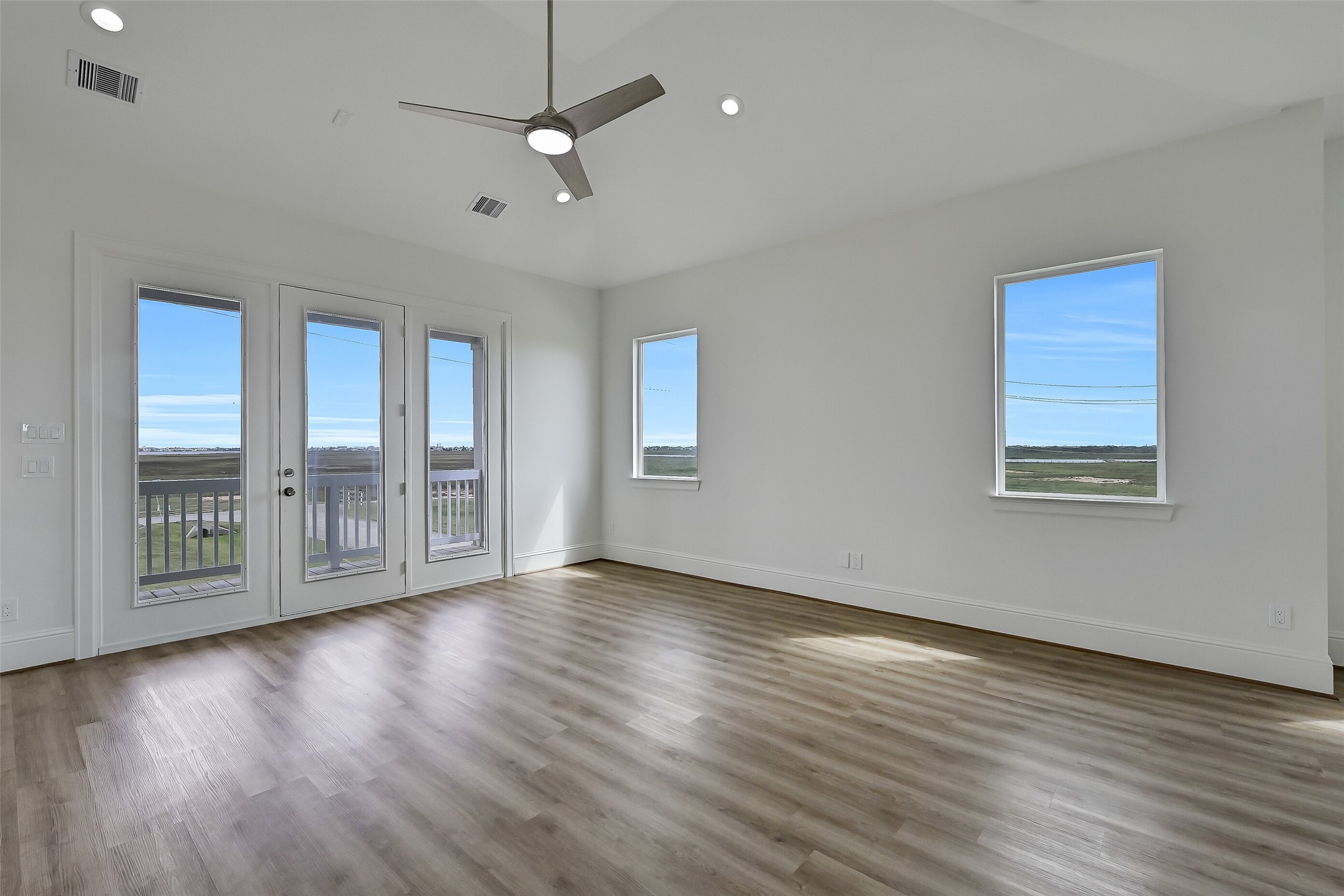 The spacious living area. An east facing deck is found through the doors ahead.
