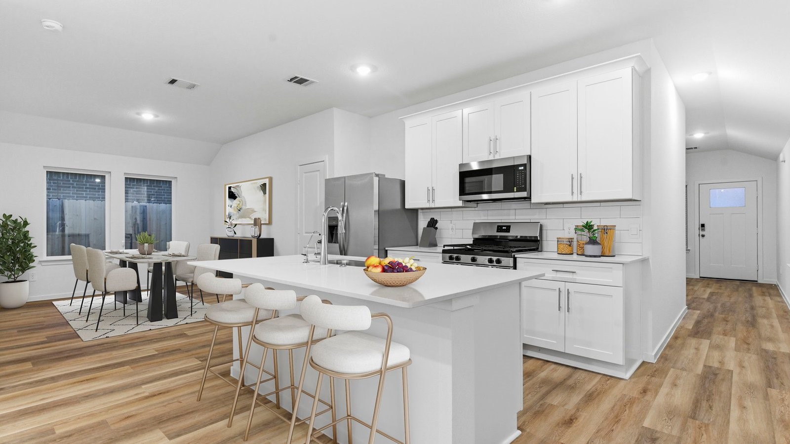 Bright and spacious kitchen with quartz countertops, stainless steel appliances, and an island with bar seating