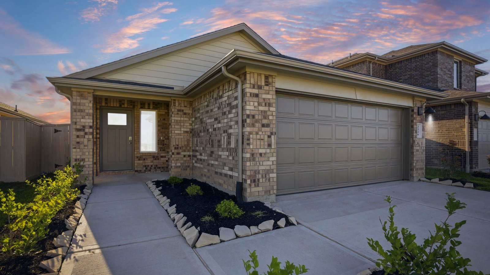 Newly built single story home with traditional architecture, a garage, and landscaped front yard.