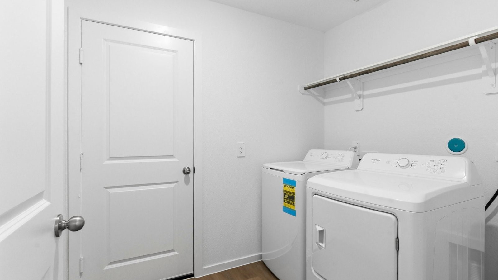 A laundry room featuring washer and dryer connections, neatly arranged with ample space for laundry tasks and storage.
