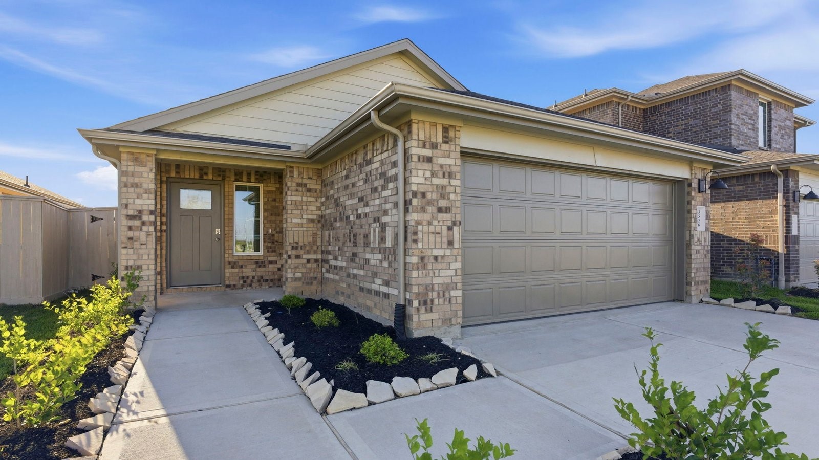 Newly built single story home with traditional architecture, a garage, and landscaped front yard.