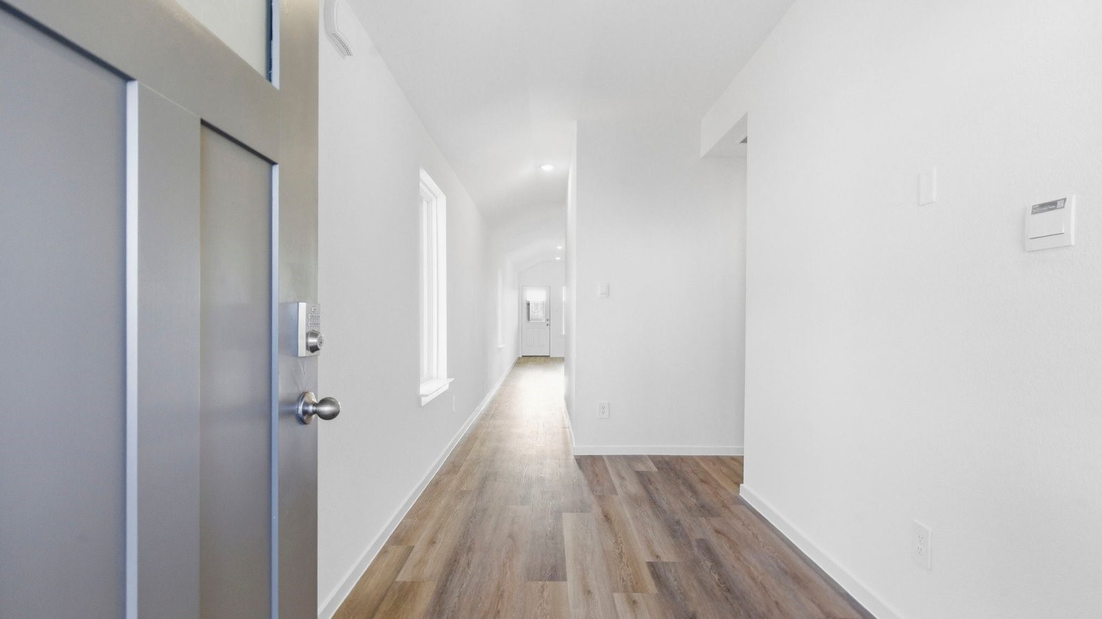 Entry hallway leading to living room and kitchen in the background.