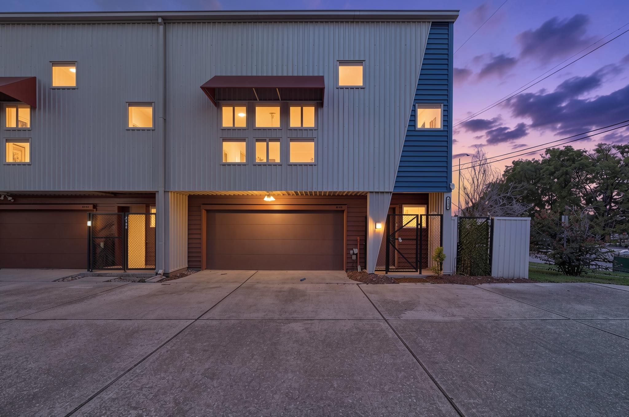 The exterior introduces a modern three-story corner-unit townhome in the Hermann Park District with clean lines, warm evening light, and attached garage access. The corner placement gives the home added presence and natural light from multiple sides The exterior introduces a modern three-story corner-unit townhome in the Hermann Park District with clean lines, warm evening light, and attached garage access. The corner placement gives the home added presence and natural light from multiple sides