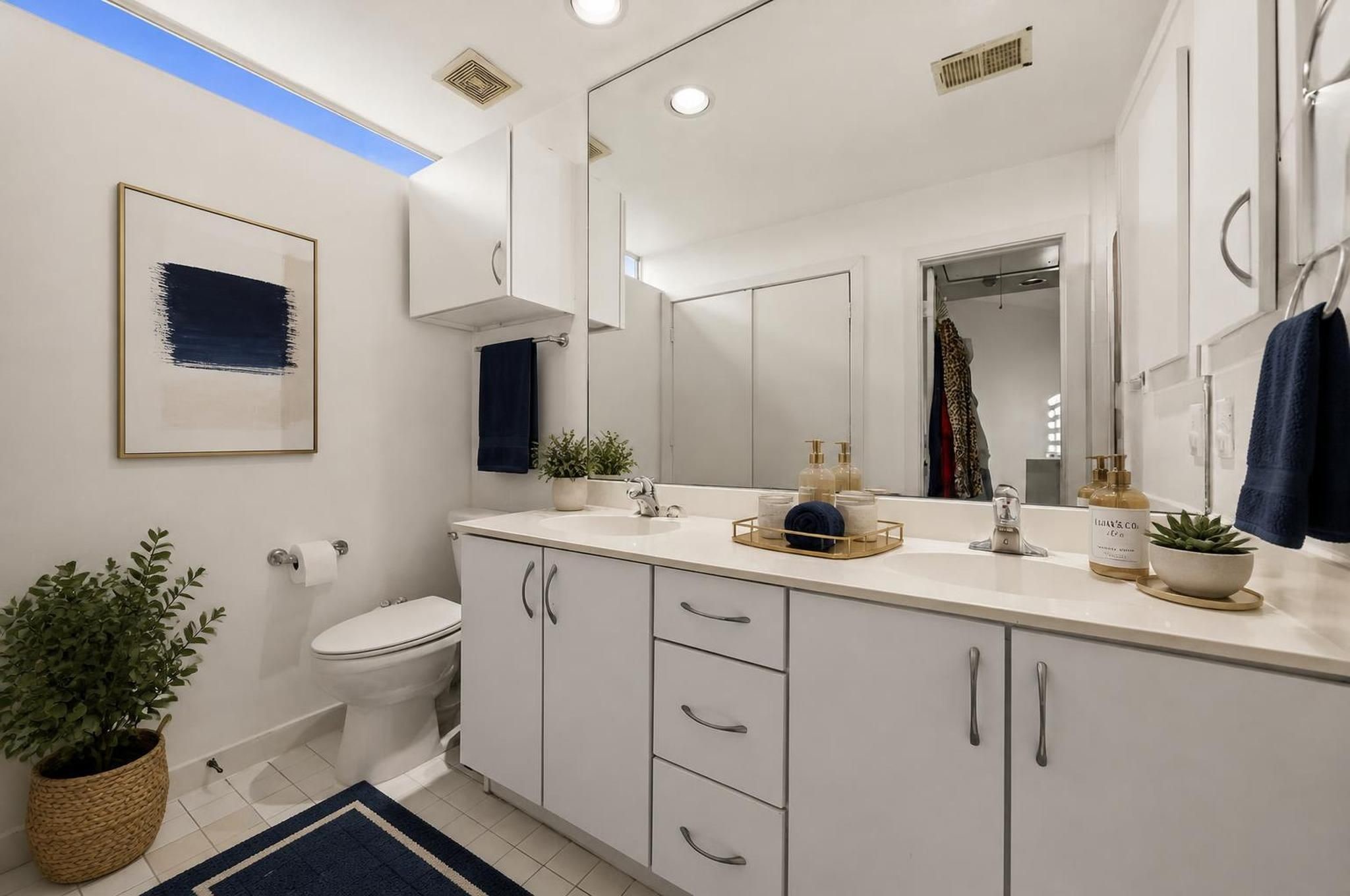 The primary bathroom features double sinks, a soaking tub, and a separate shower for a complete ensuite setup. Its placement within the third-floor suite gives the primary level a private, finished feel. Virtually staged.