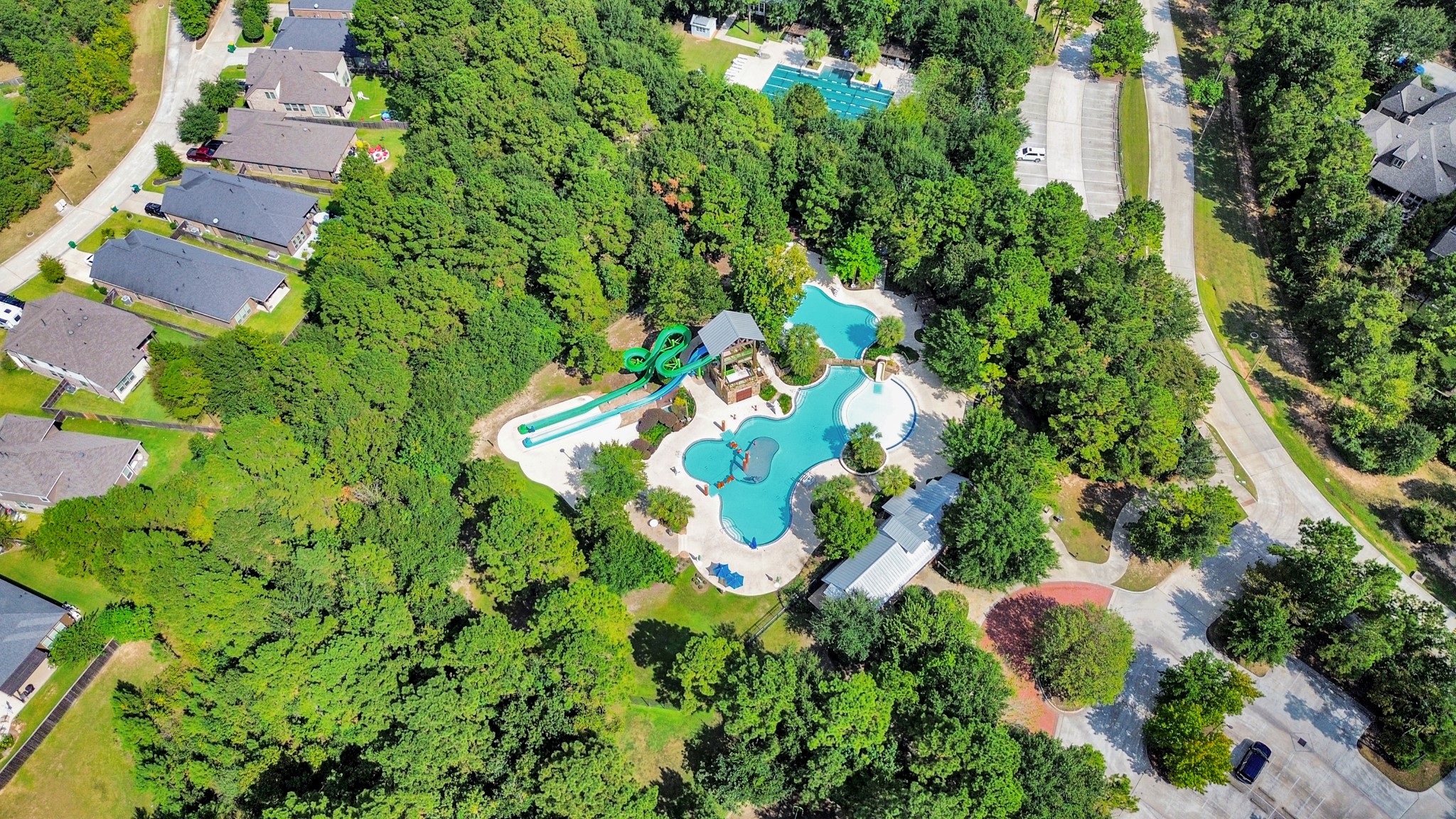 Nestled in a lush green setting, this community features a stunning pool area with winding water slides and ample lounging space, perfect for relaxation and recreation.
