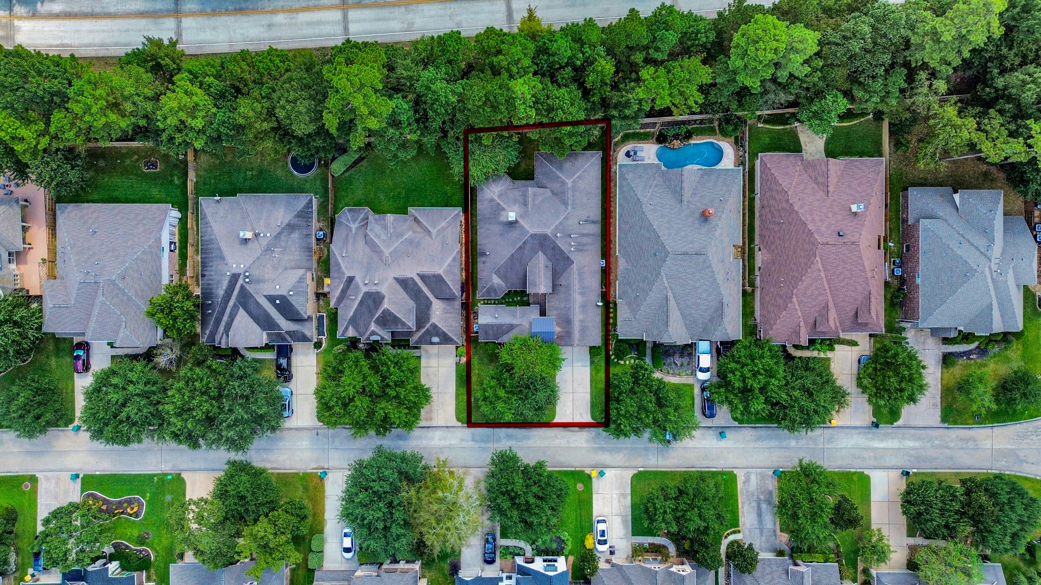 Charming suburban home nestled in a tree-lined neighborhood, featuring a spacious backyard bordering lush greenery. The property offers a generous driveway and is part of a peaceful community with easy access to nearby amenities.