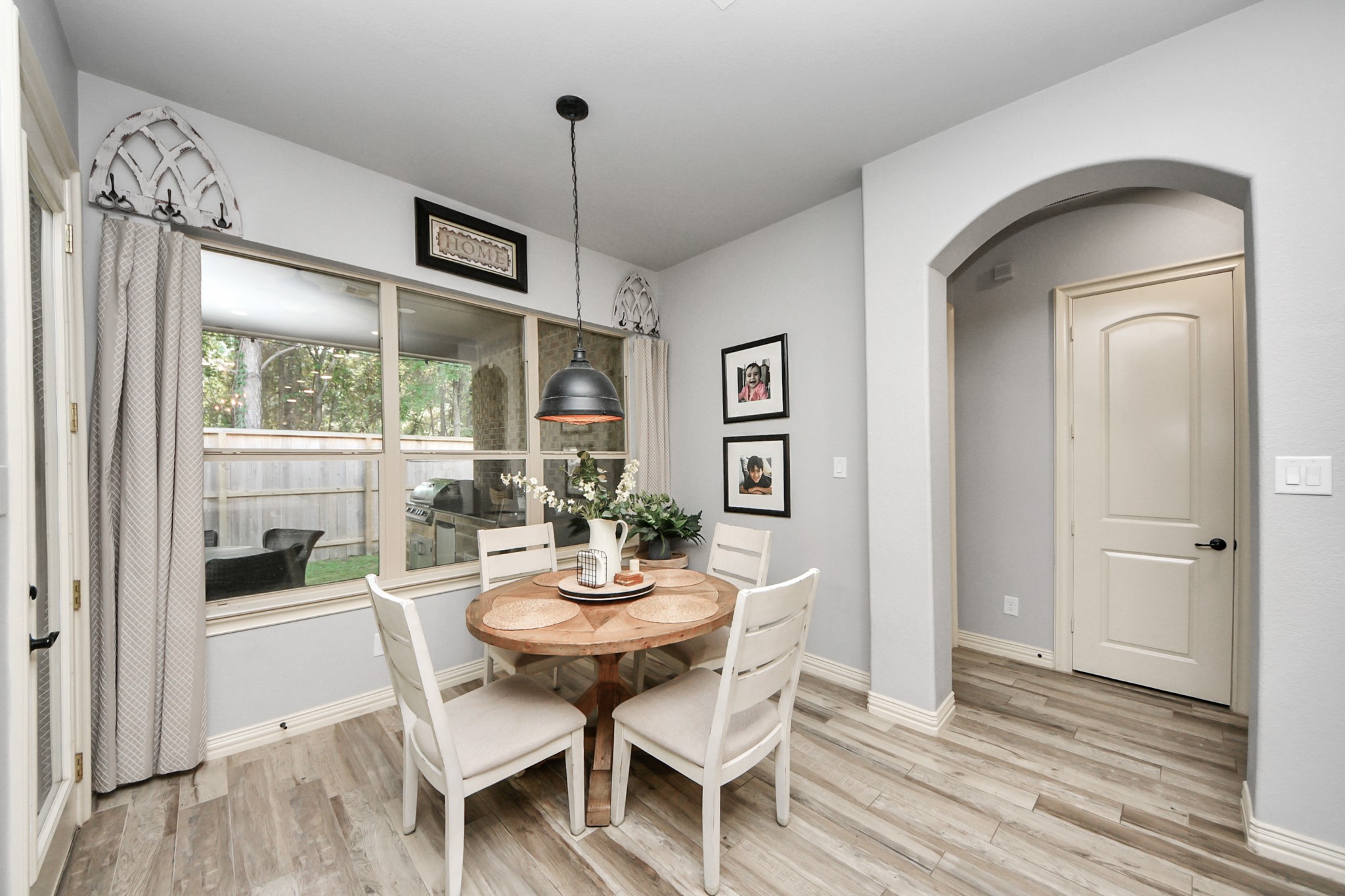Charming Breakfast area with natural light streaming through large windows, featuring a cozy round table and stylish pendant lighting, perfect for intimate gatherings.