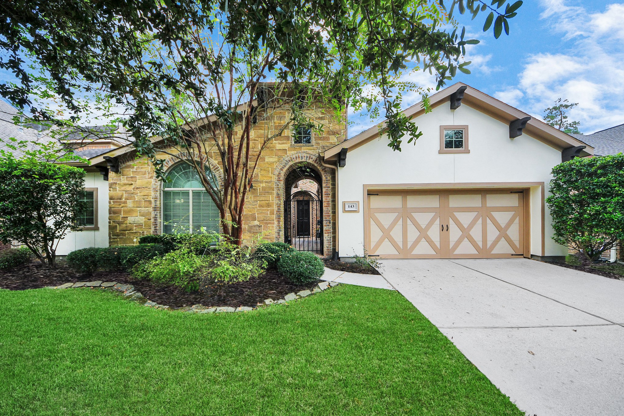 Charming home with a beautiful stone facade, arched entryway, and a two-car garage. Lush landscaping and mature trees enhance its curb appeal. Charming home with a beautiful stone facade, arched entryway, and a two-car garage. Lush landscaping and mature trees enhance its curb appeal.