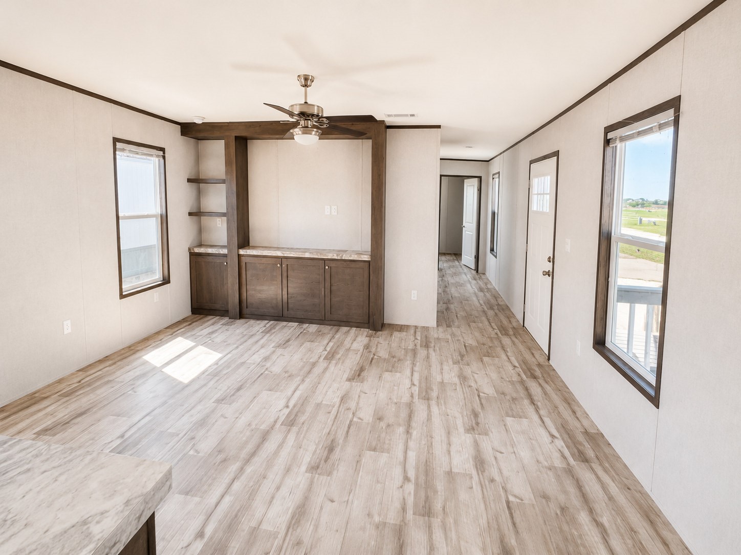 Step into this bright and spacious living room, designed for comfort and everyday living! Featuring gorgeous wood-look flooring, beautiful natural light, a stylish ceiling fan, and a built-in entertainment center with shelving and storage, this inviting space is perfect for relaxing or entertaining guests. The open layout creates a warm and welcoming atmosphere you'll love coming home to!