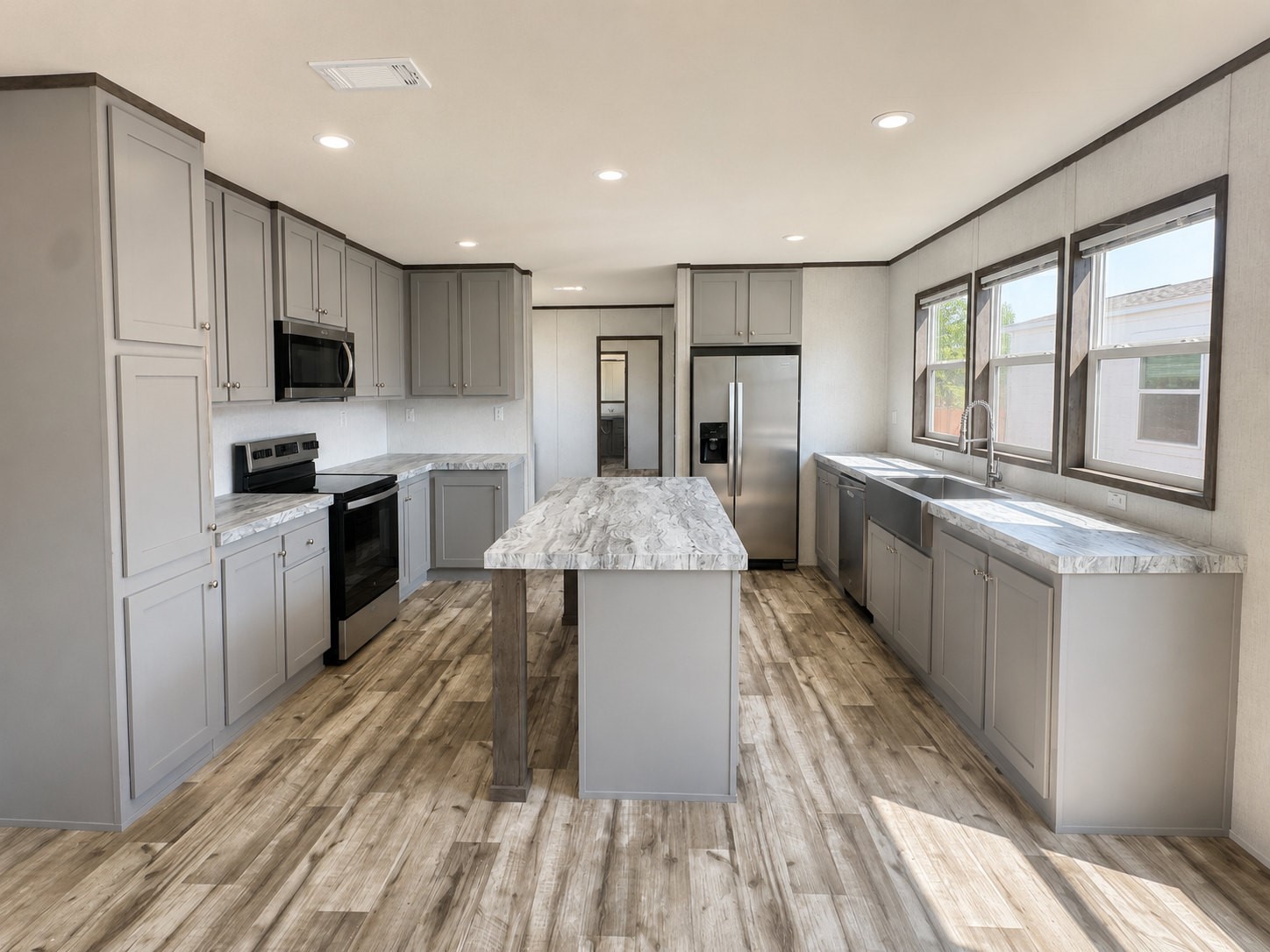 Fall in love with this stunning, modern kitchen featuring beautiful gray cabinetry, elegant marble-look countertops, and a spacious center island perfect for meal prep and entertaining! Enjoy stainless steel appliances, a stylish farmhouse sink, abundant cabinet space, and gorgeous wood-look flooring. Large windows fill the space with natural light, creating a bright and inviting atmosphere!