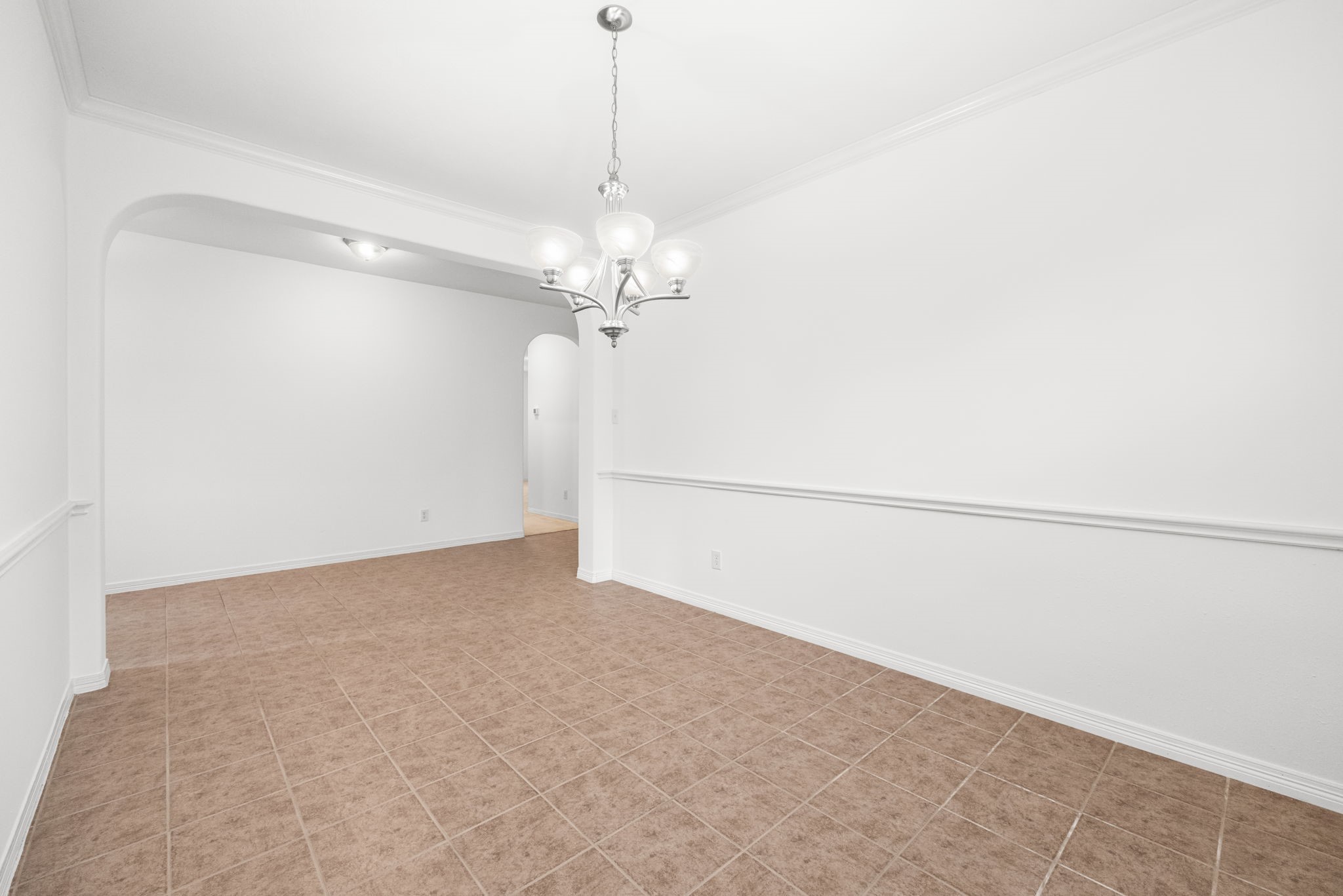 A graceful archway lends definition to the formal dining room, setting it apart while maintaining an easy connection to the foyer and surrounding living spaces.