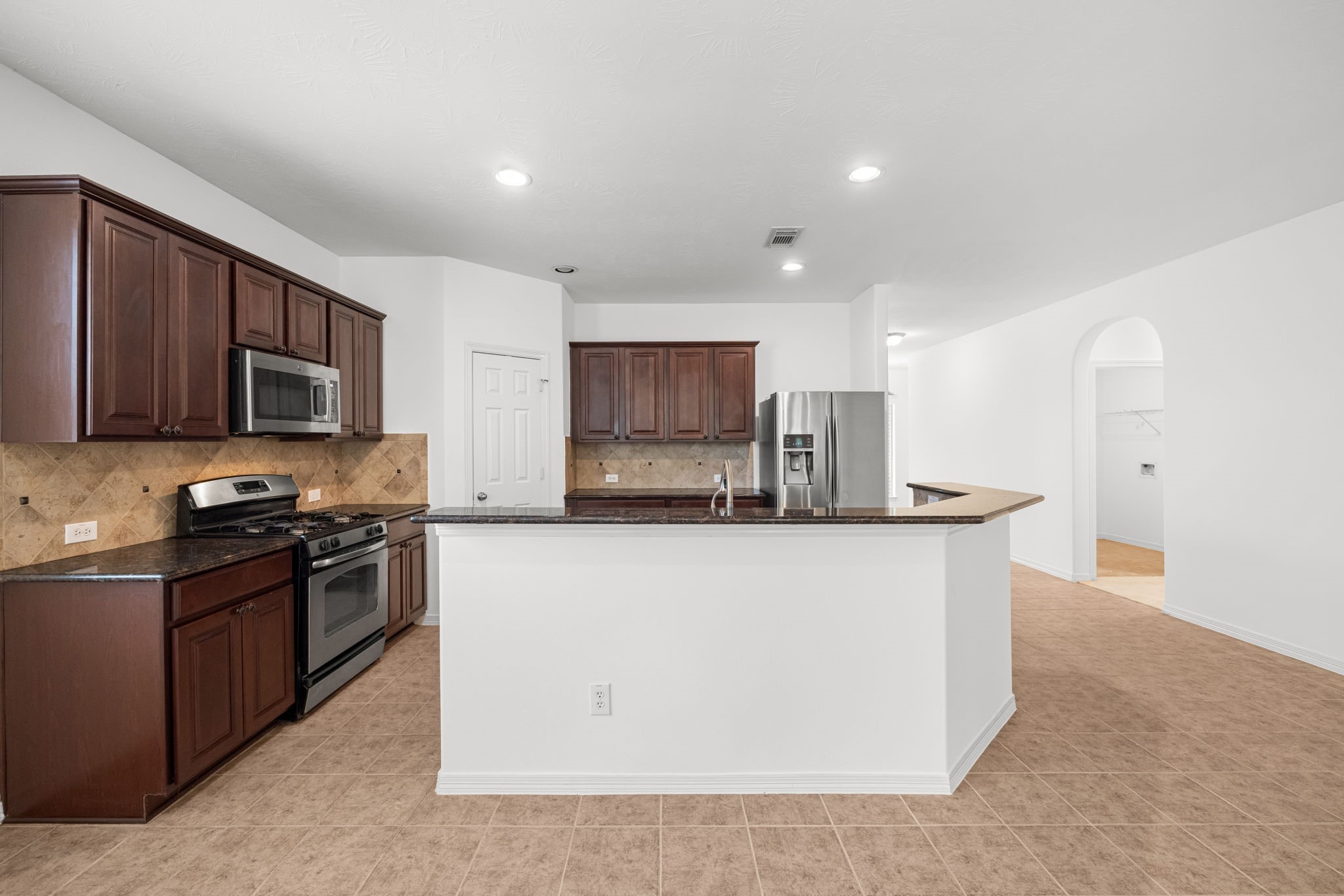 Espresso-finished cabinetry accentuate the kitchen with rich contrast, while extensive countertops provide room to prepare meals, arrange serving dishes, and keep entertaining essentials close at hand.