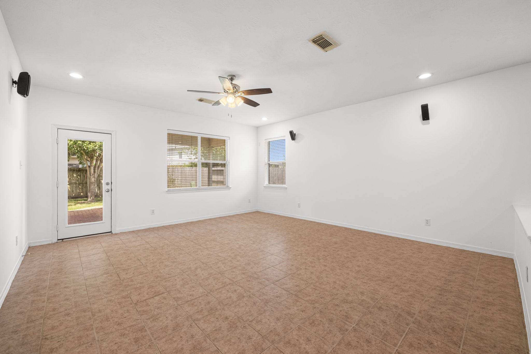 Recessed lighting and a clean interior palette give the living room a fresh, open feel, while a glass-paneled door provides direct access to the covered rear patio for an easy change of scenery.