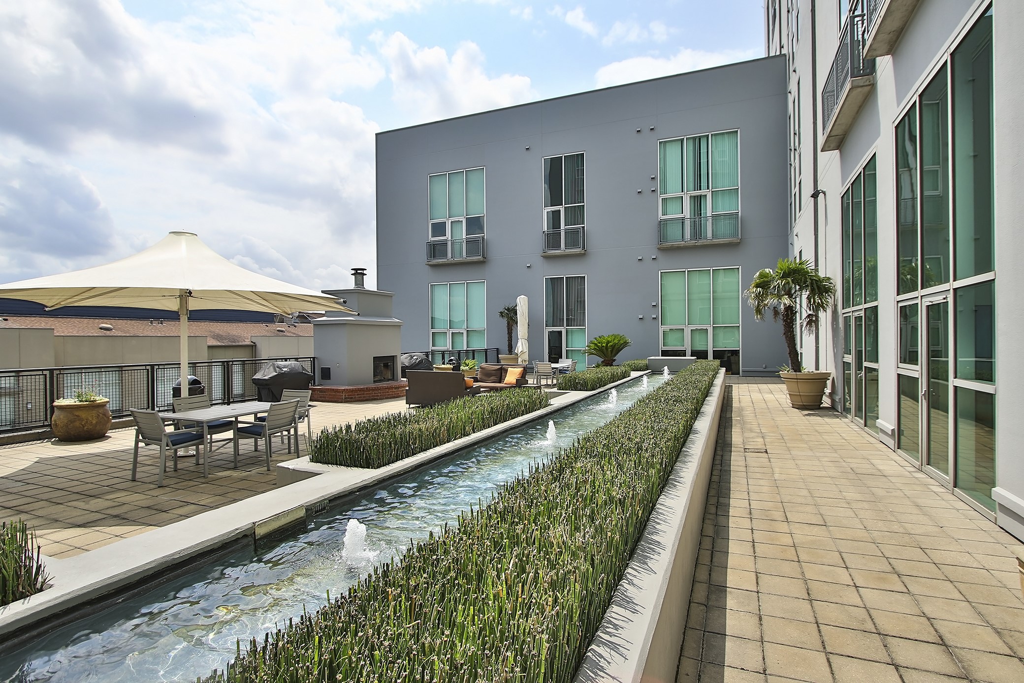 5th floor Eden offers a lush garden deck with Zen fountain, fireplace, grills, and shady gathering umbrellas. Relax or entertain in this outdoor space.