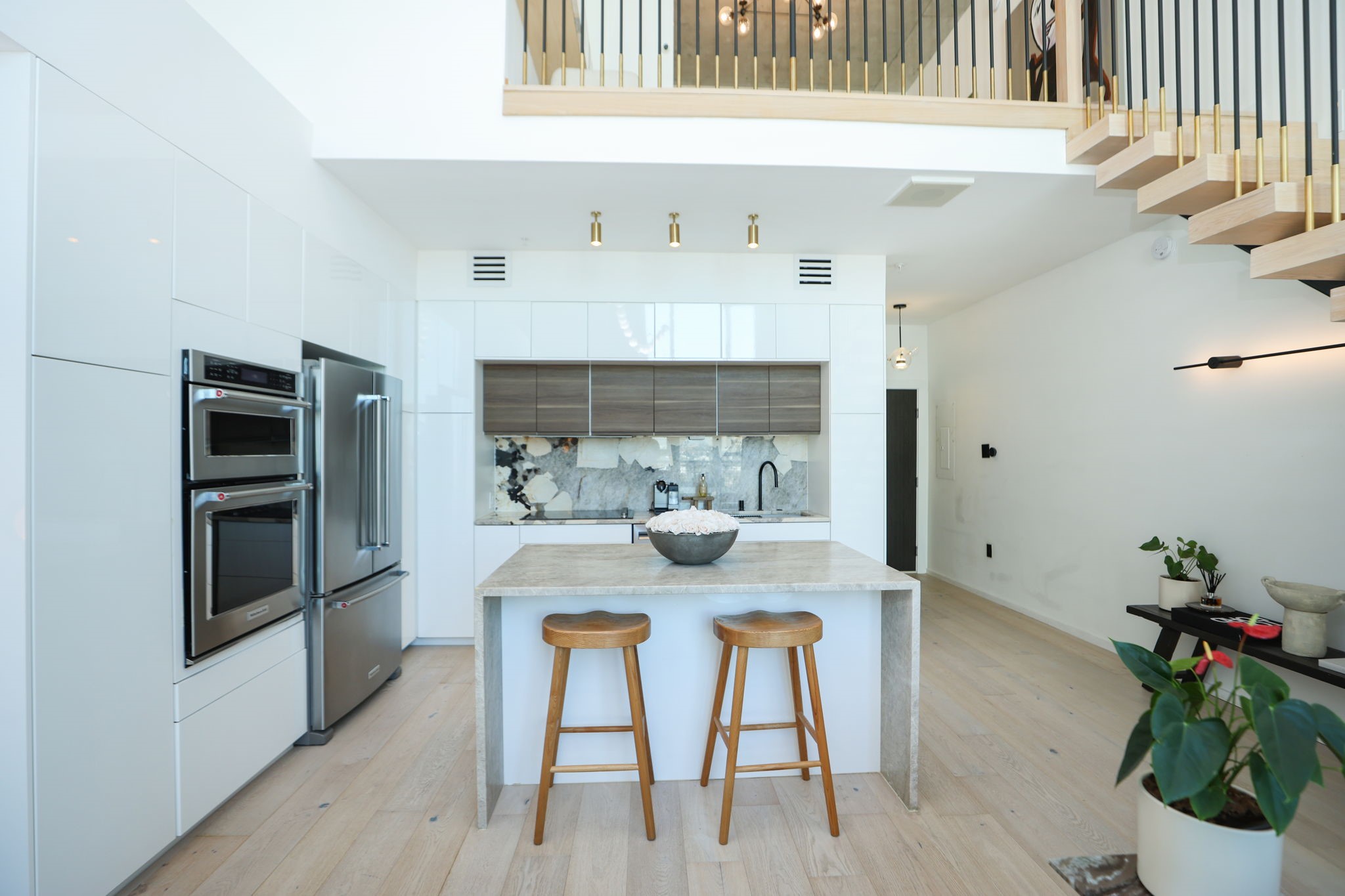 Upscale finished from floor to ceiling, including wide plank white oak engineered flooring, Calcutta marble, and brass accent lighting.