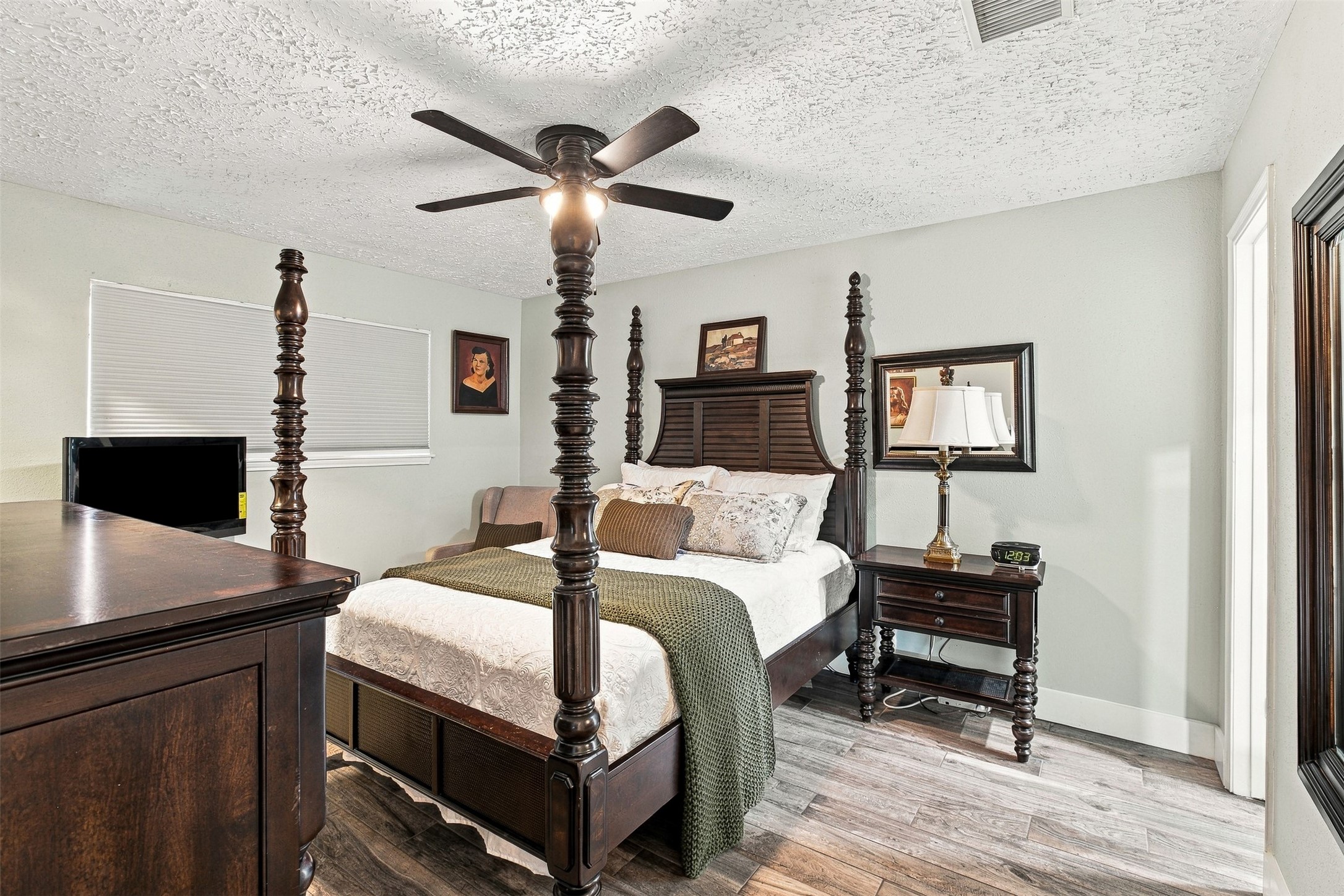 Primary bedroom offers generous space for substantial furnishings, updated flooring, ceiling fan, and private bath access.