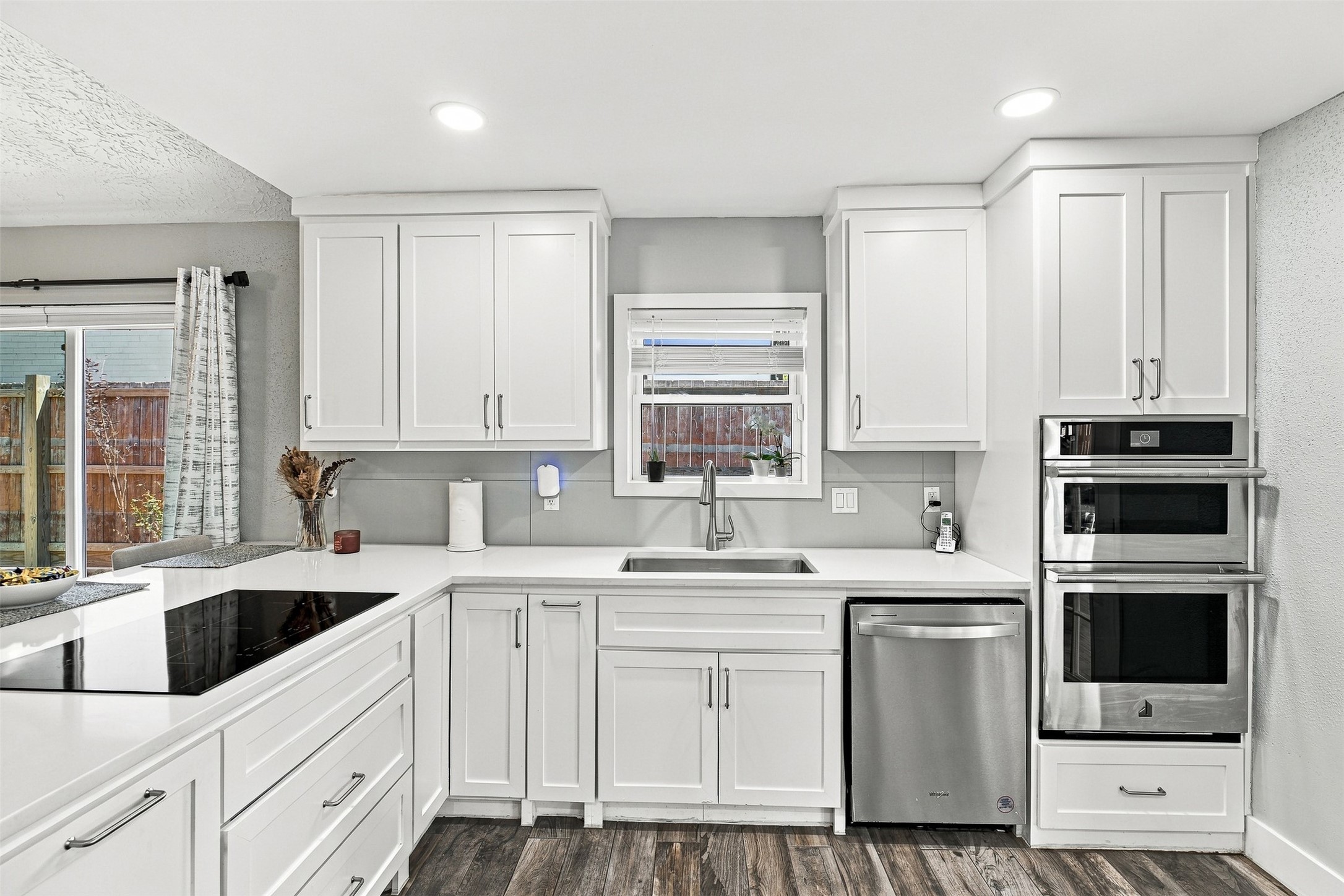 Updated kitchen with modern white cabinetry with handles, quartz countertops, stainless steel appliances, undermount sink, and abundant storage for your inspired chef kitchen.