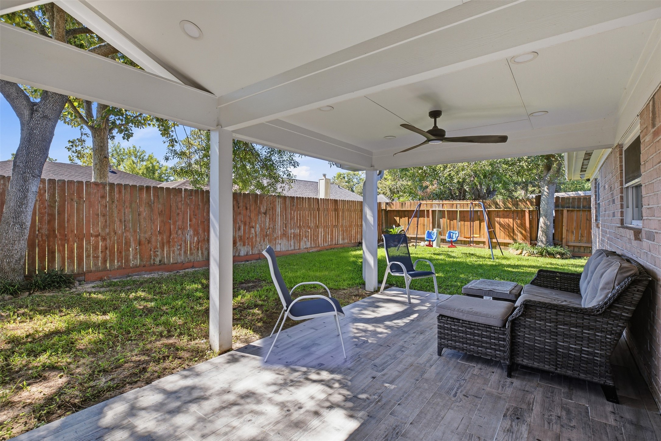 Expansive covered patio extends the living space outdoors and overlooks the fenced backyard with modern fans with recessed lighted along with the beautiful mature shaded trees!