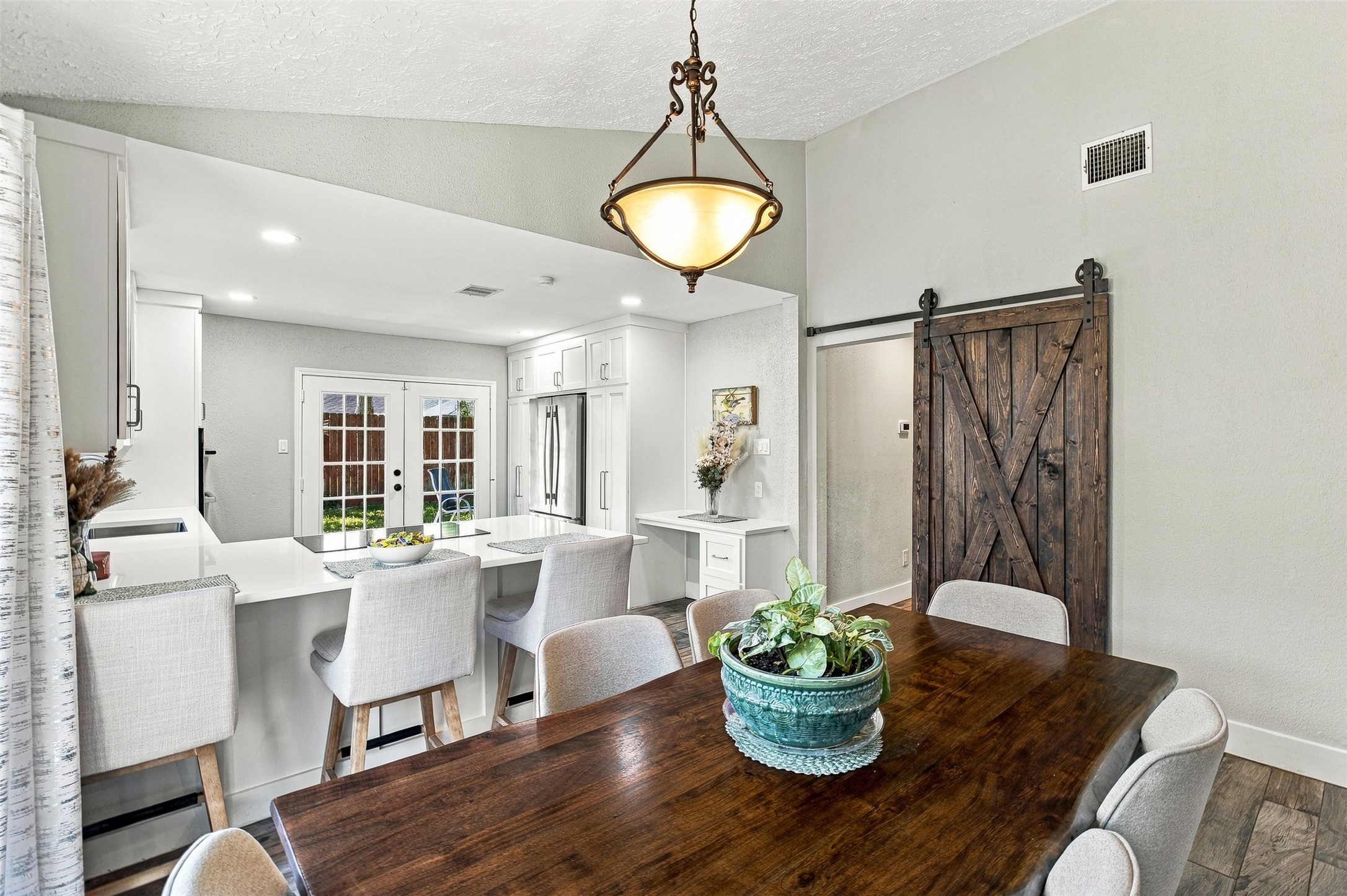 Open dining and kitchen layout creates an inviting space for everyday living and entertaining. Sliding barn door adds character and warmth.
