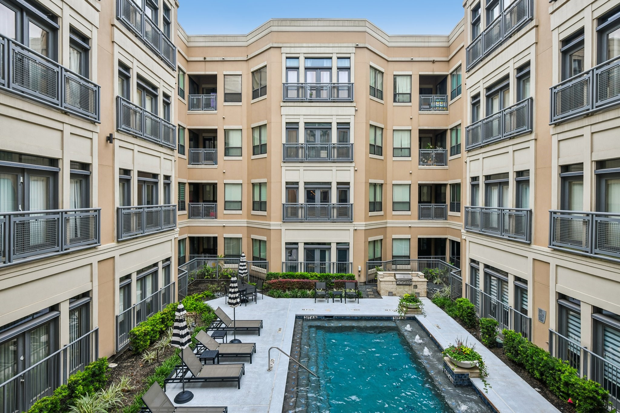 Lofts at Post Oak offers 6 pools with loungers- outdoor kitchens